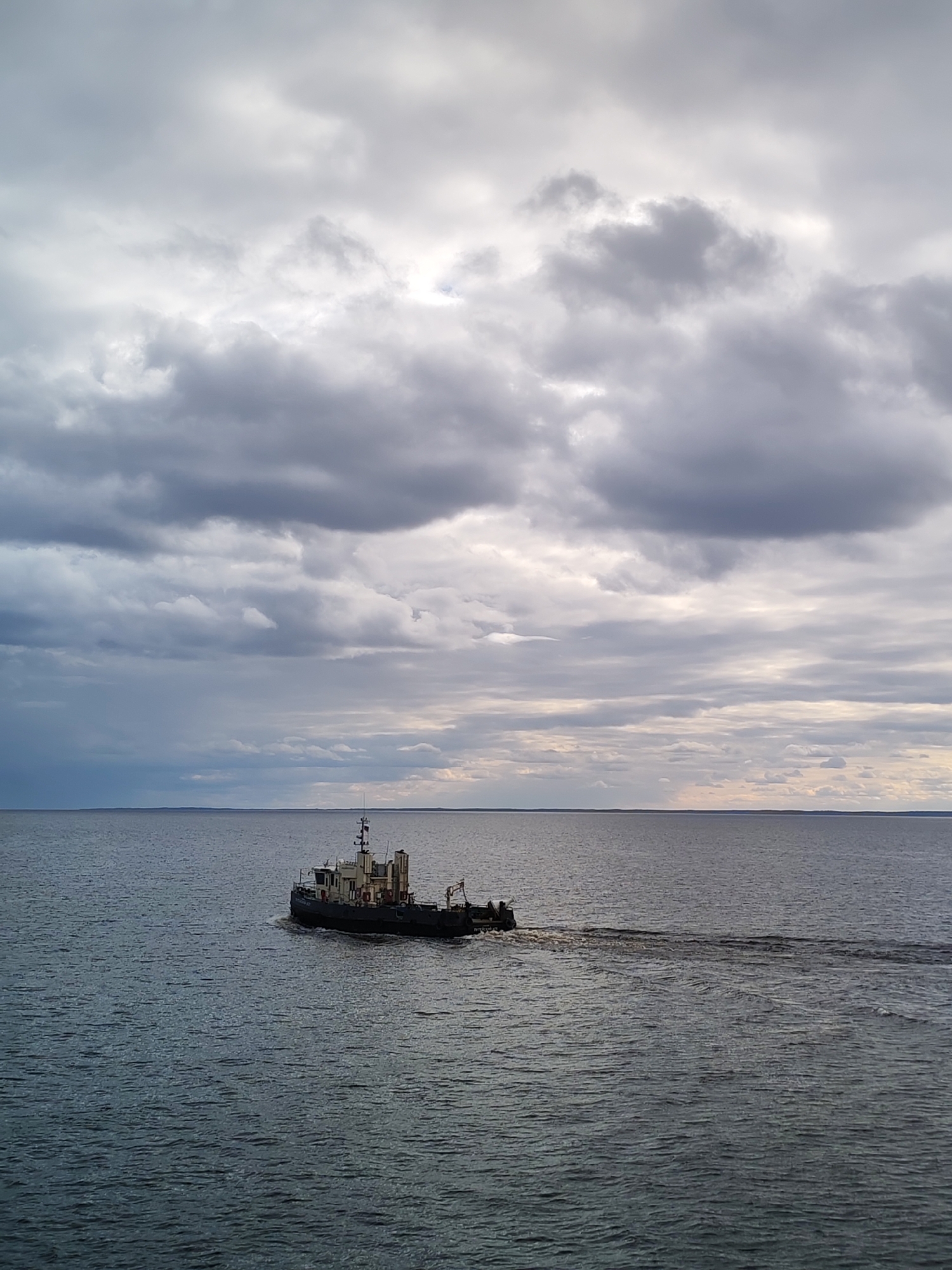 Lone boat spotted under dramatic overcast skies in Russia