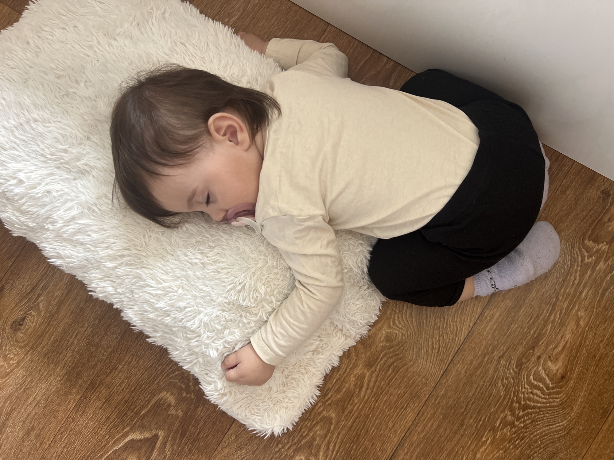 Child naps peacefully on fluffy rug in Elena, Bulgaria