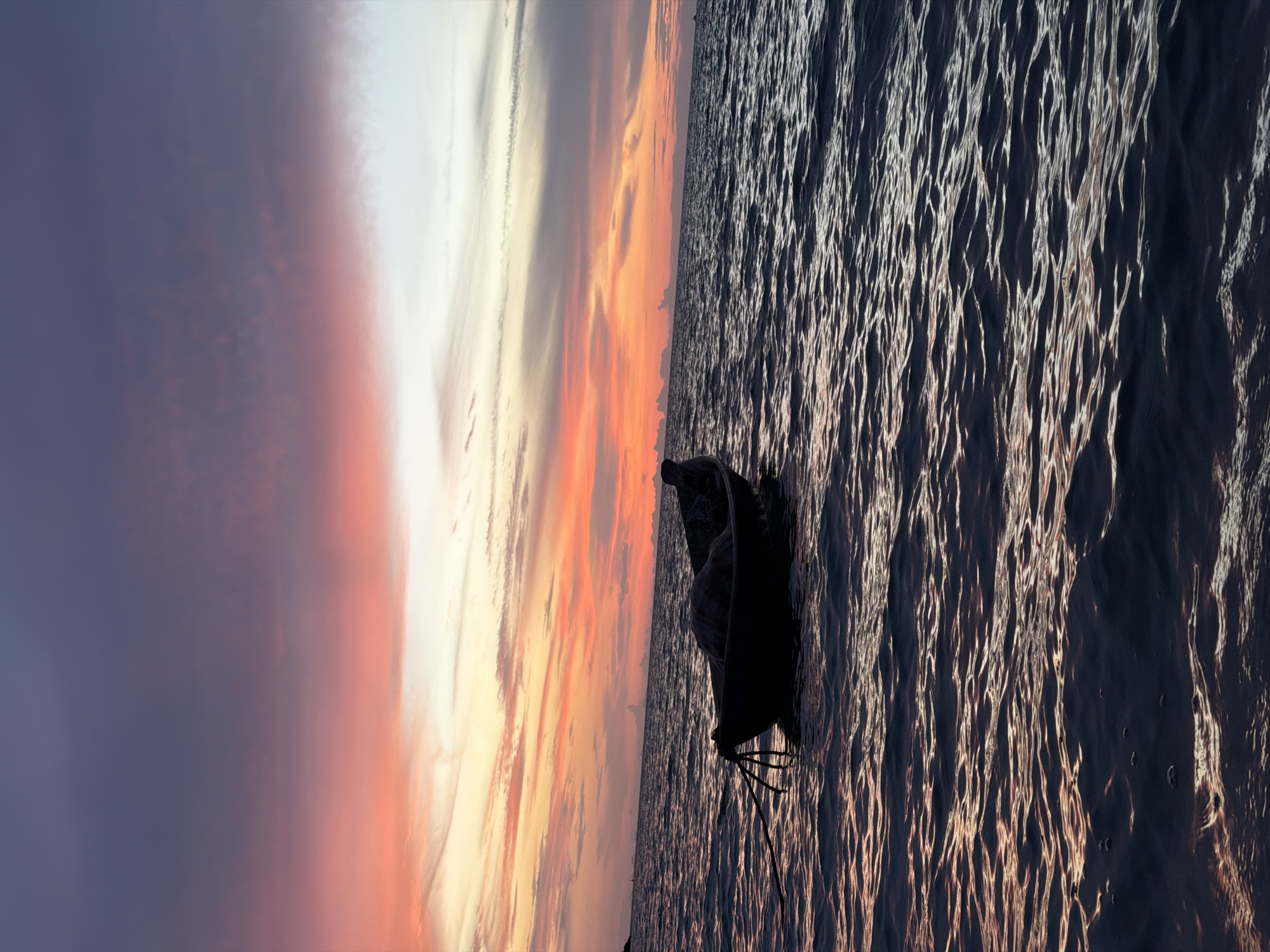 Fishing boat silhouetted against a vivid Ko Samui sunset