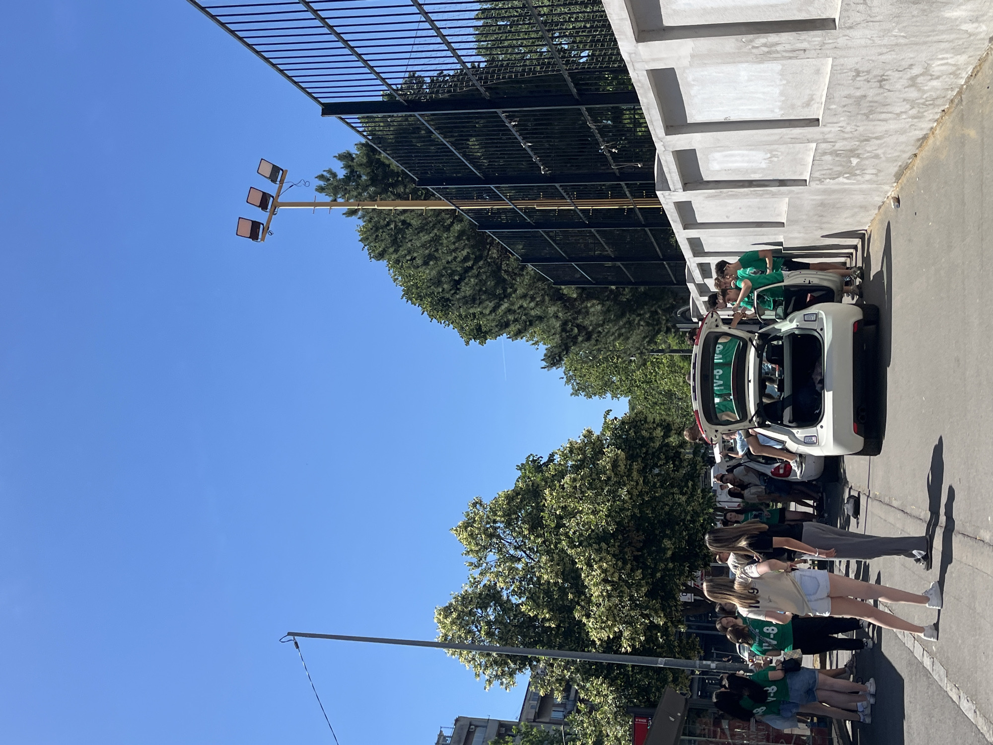 Group in matching shirts gathers around car in Belgrade