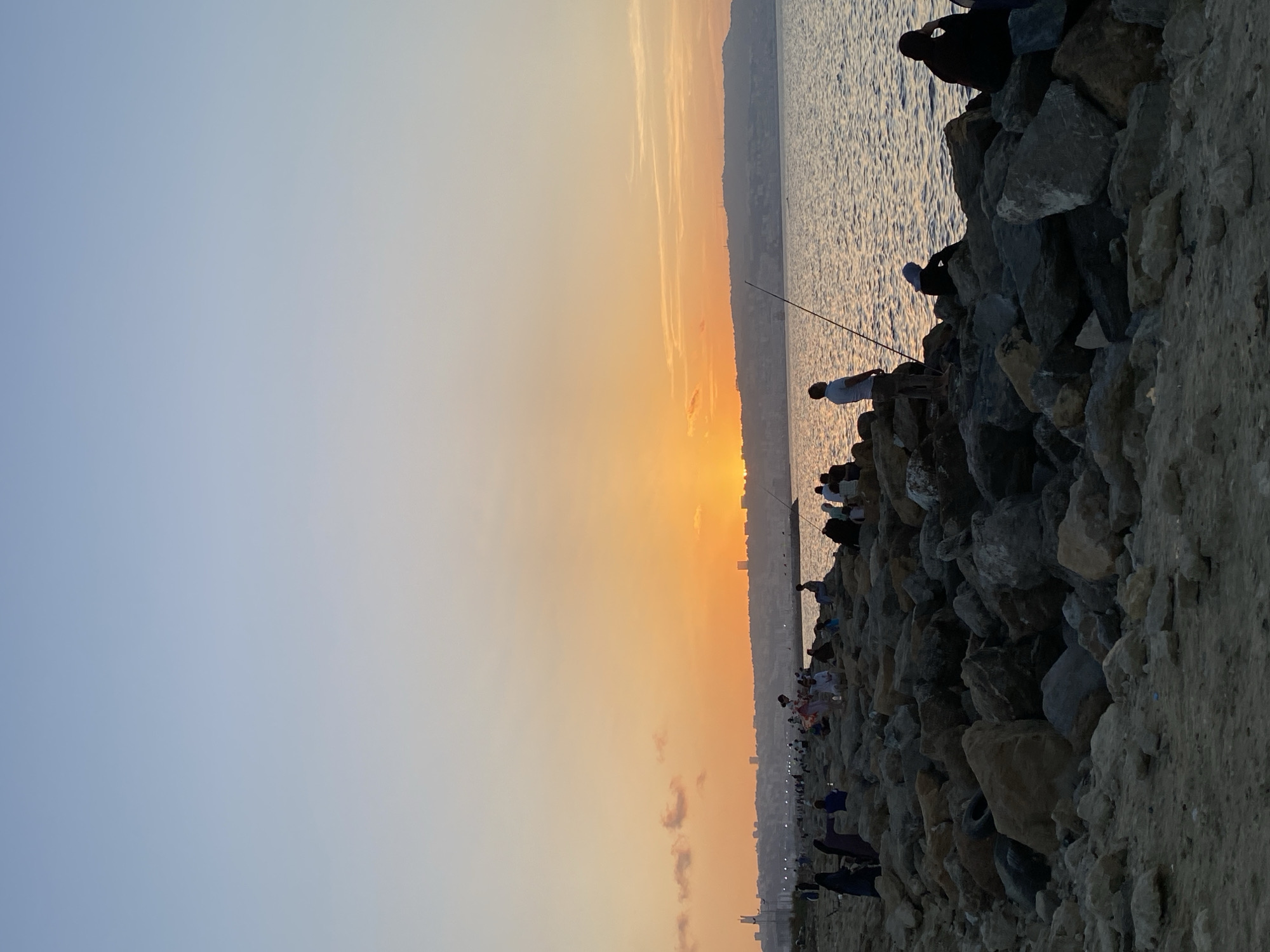 Sunset along Mohammadia's rocky breakwater, fishing and leisure.