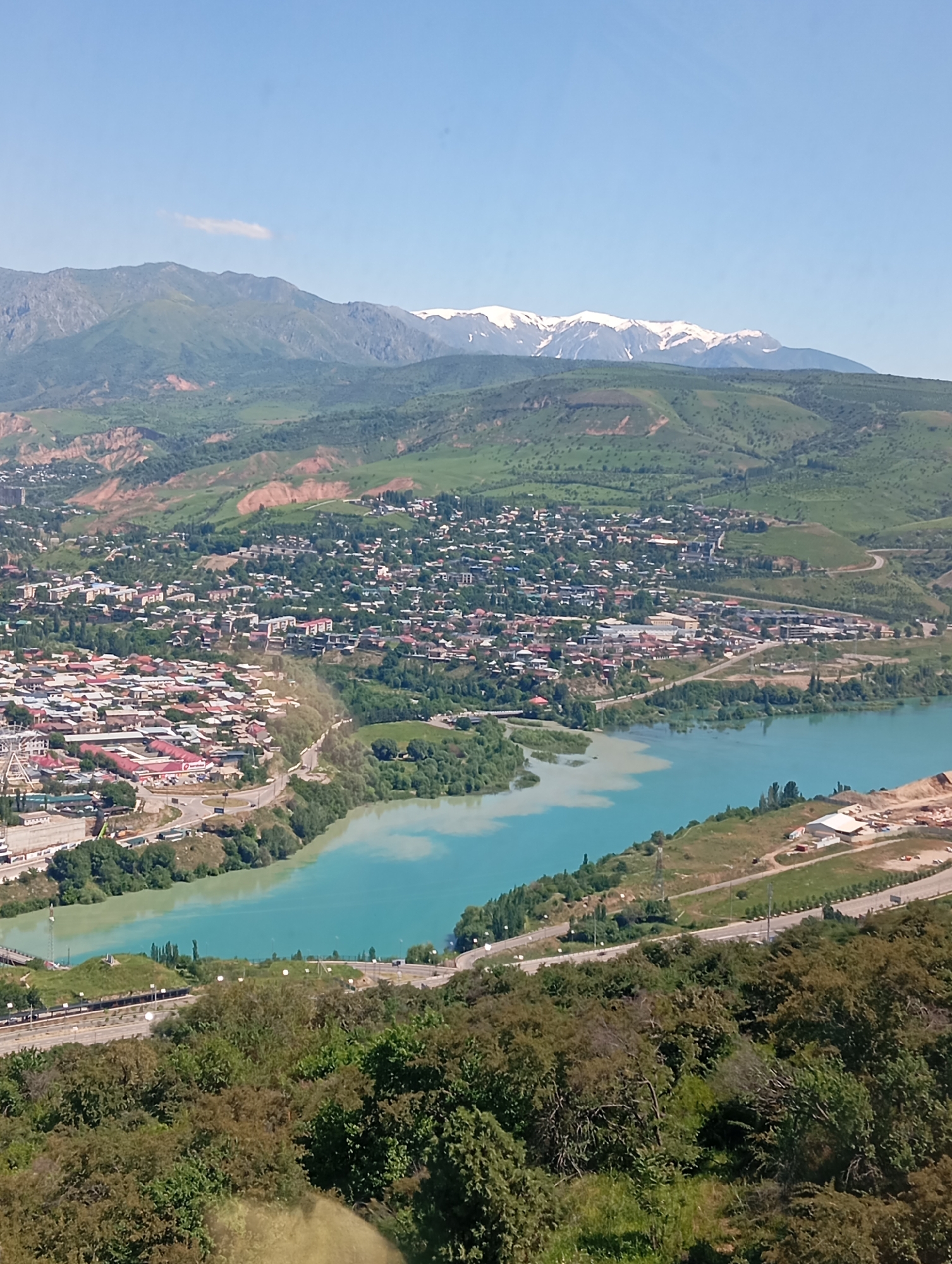 Aerial view captures Chinarkent valley with turquoise river, highway