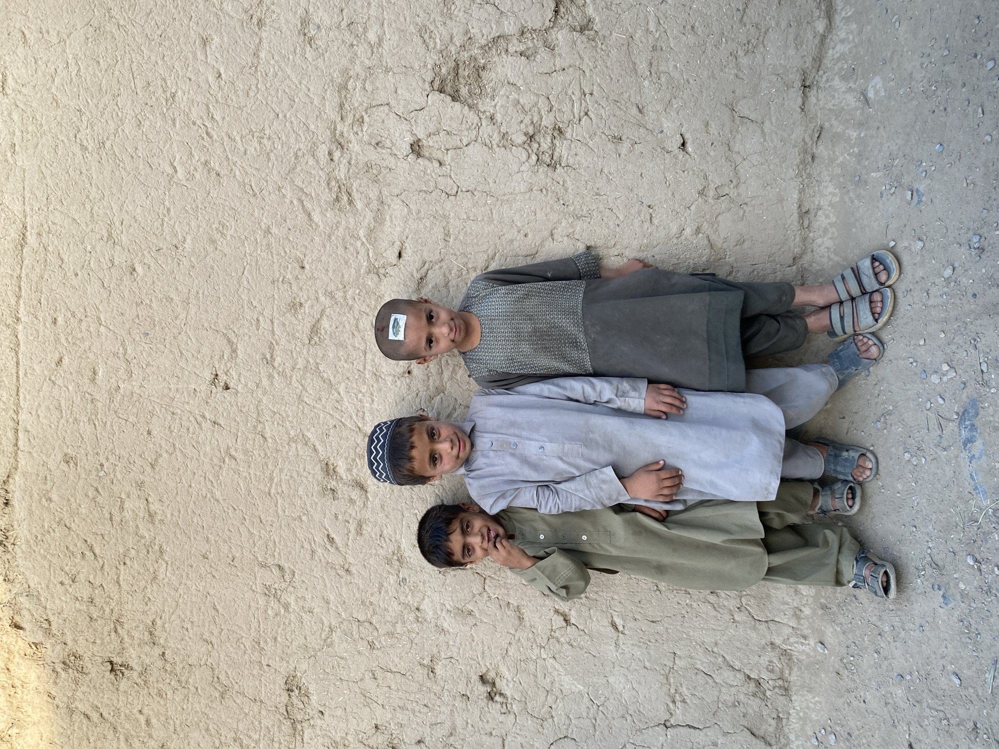 Everyday life near a mud-brick wall in Arghandab, Afghanistan