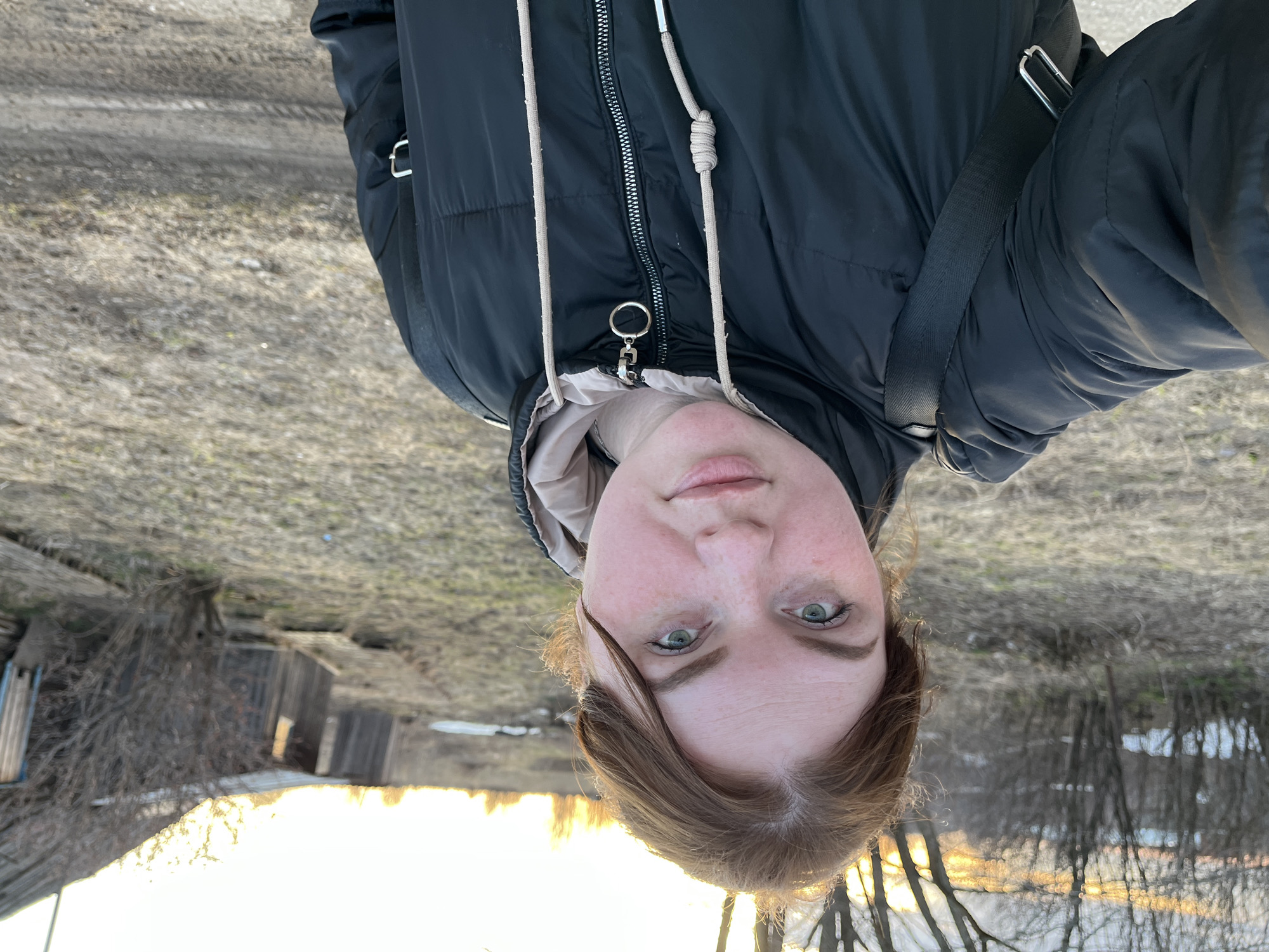 Woman takes selfies in rural Pavlovka under cloudy skies