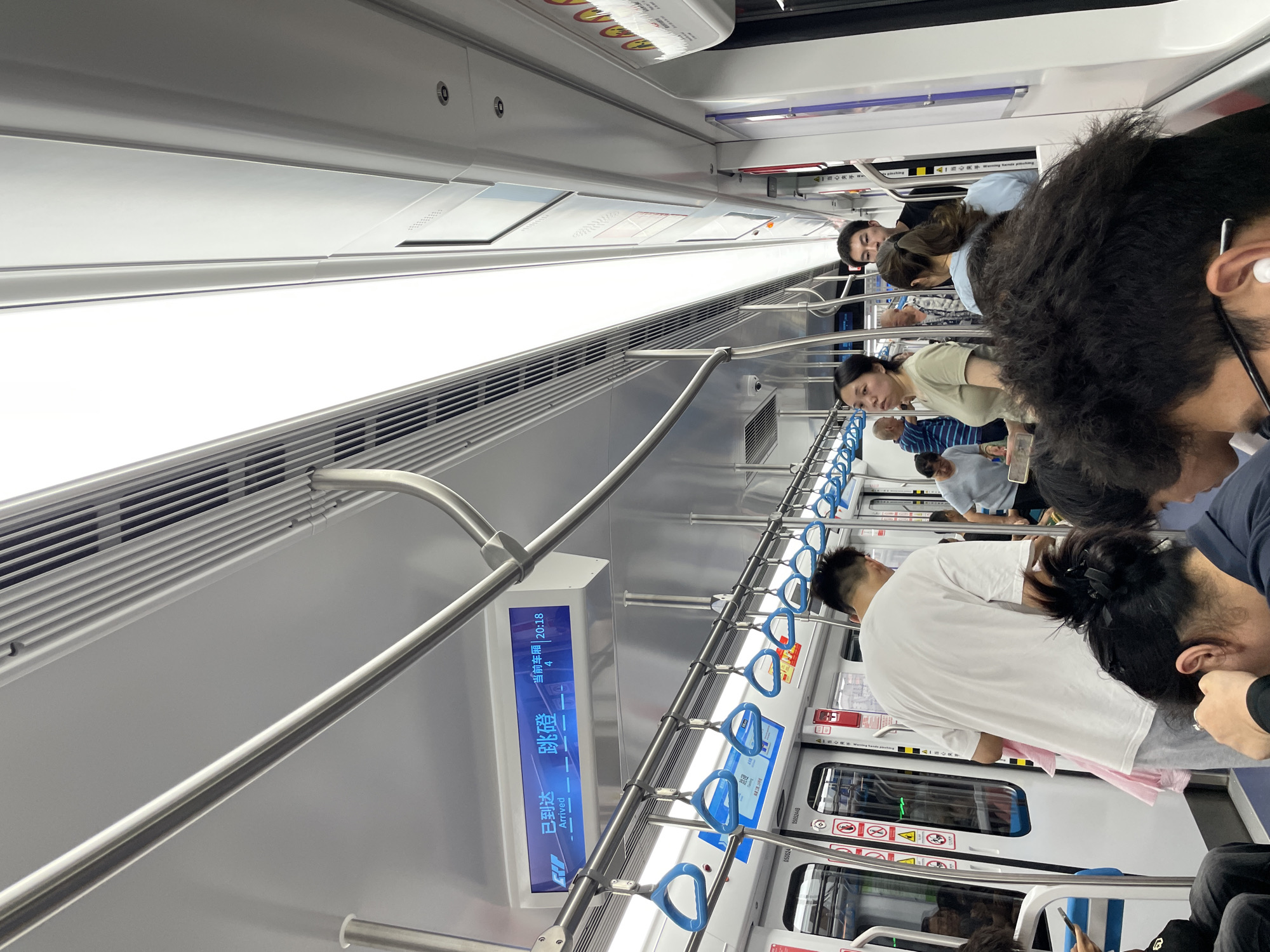 Passengers travel on subway car with bags during midday