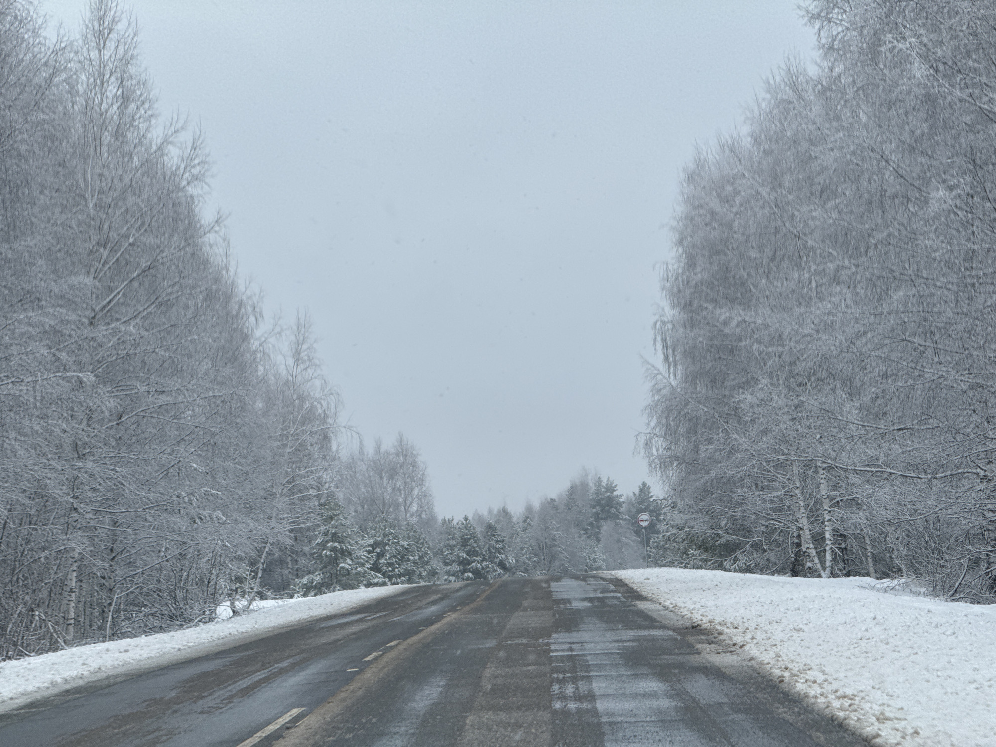 Spring snow blankets rural road in Zhigalki, Russia