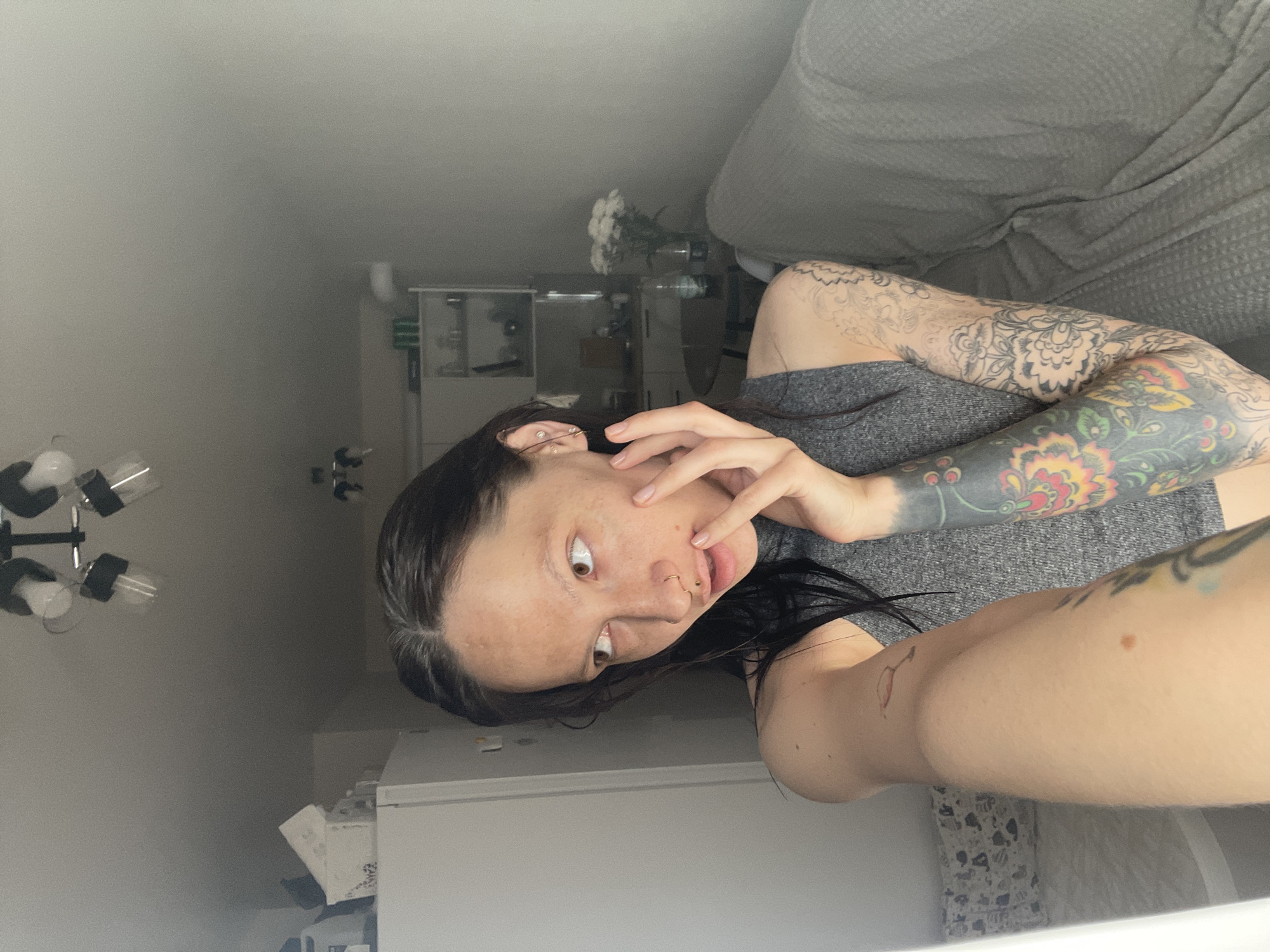 Woman with tattoos observed indoors near furniture