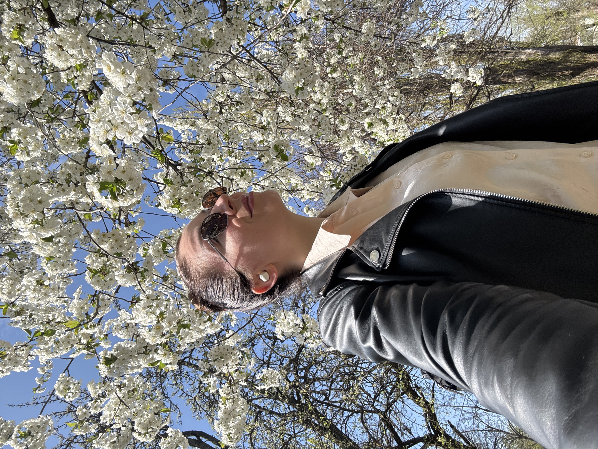 Person photographed looking skyward near flowering tree in Kryvyi Rih