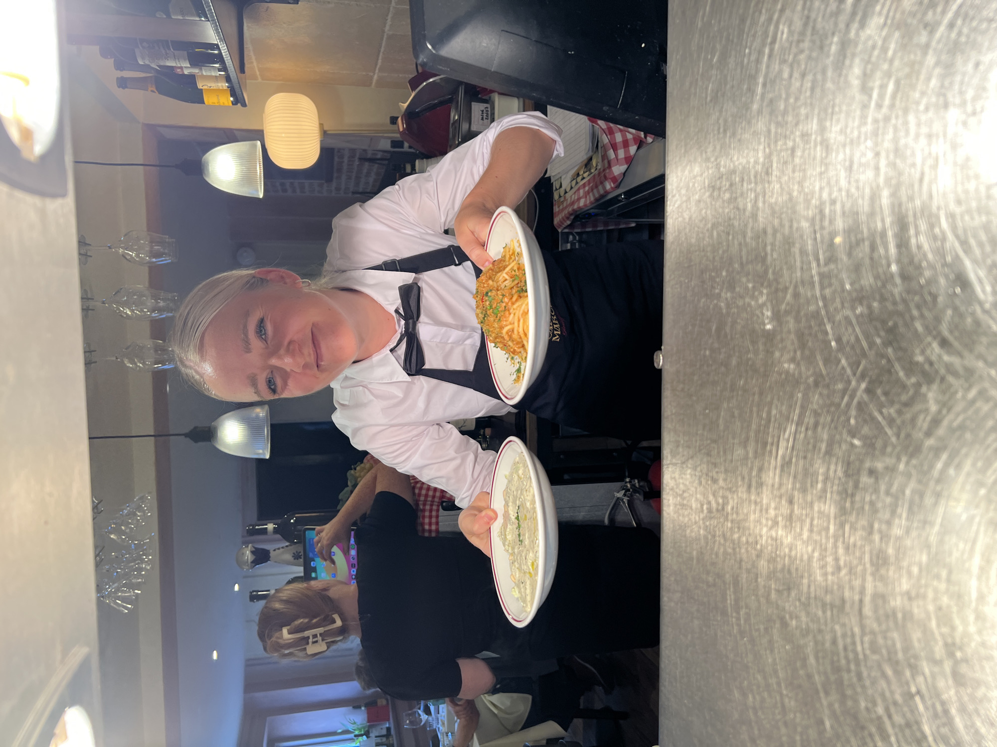 Server carries plated dishes through a Guildford restaurant