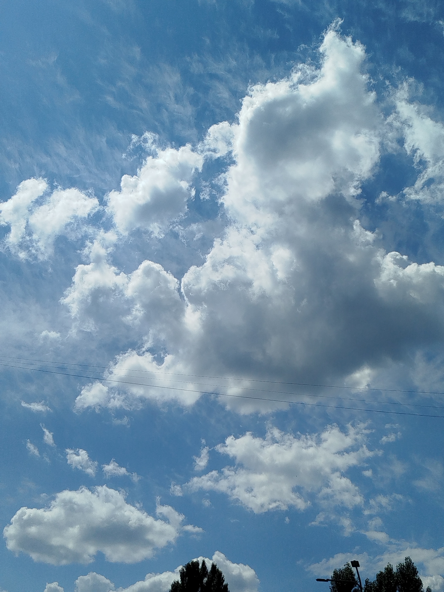 Clouds drift over Kremenchuk skies, power lines in frame