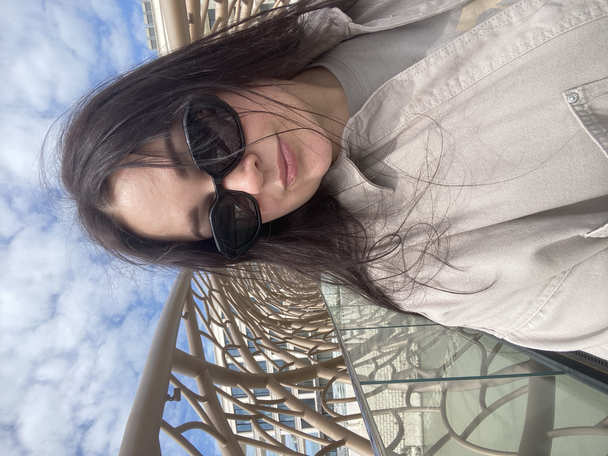 Woman photographs modern sculptural bridge in Sochi waterfront area