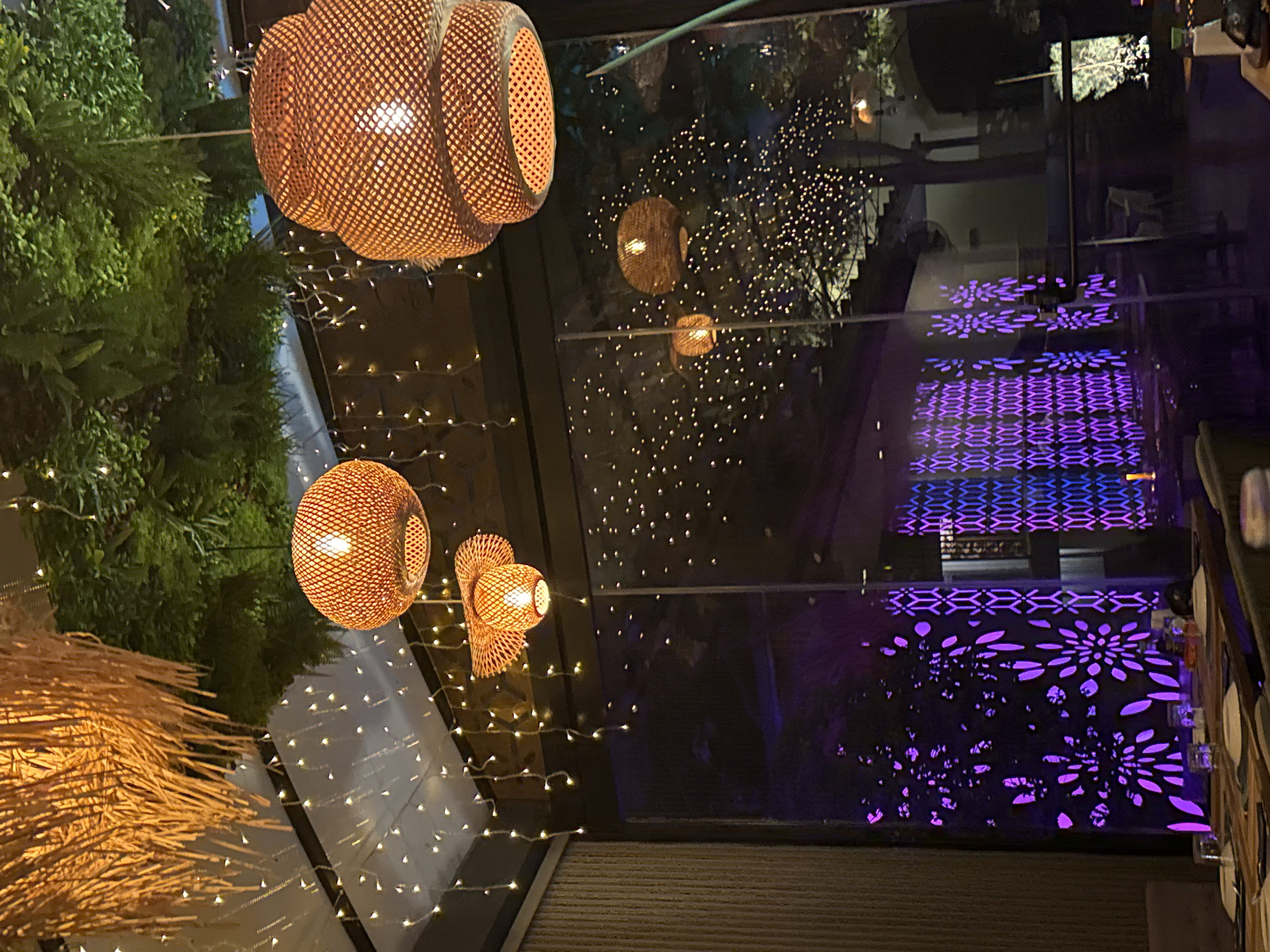 Restaurant with wicker lighting and green decor observed in Larnaca