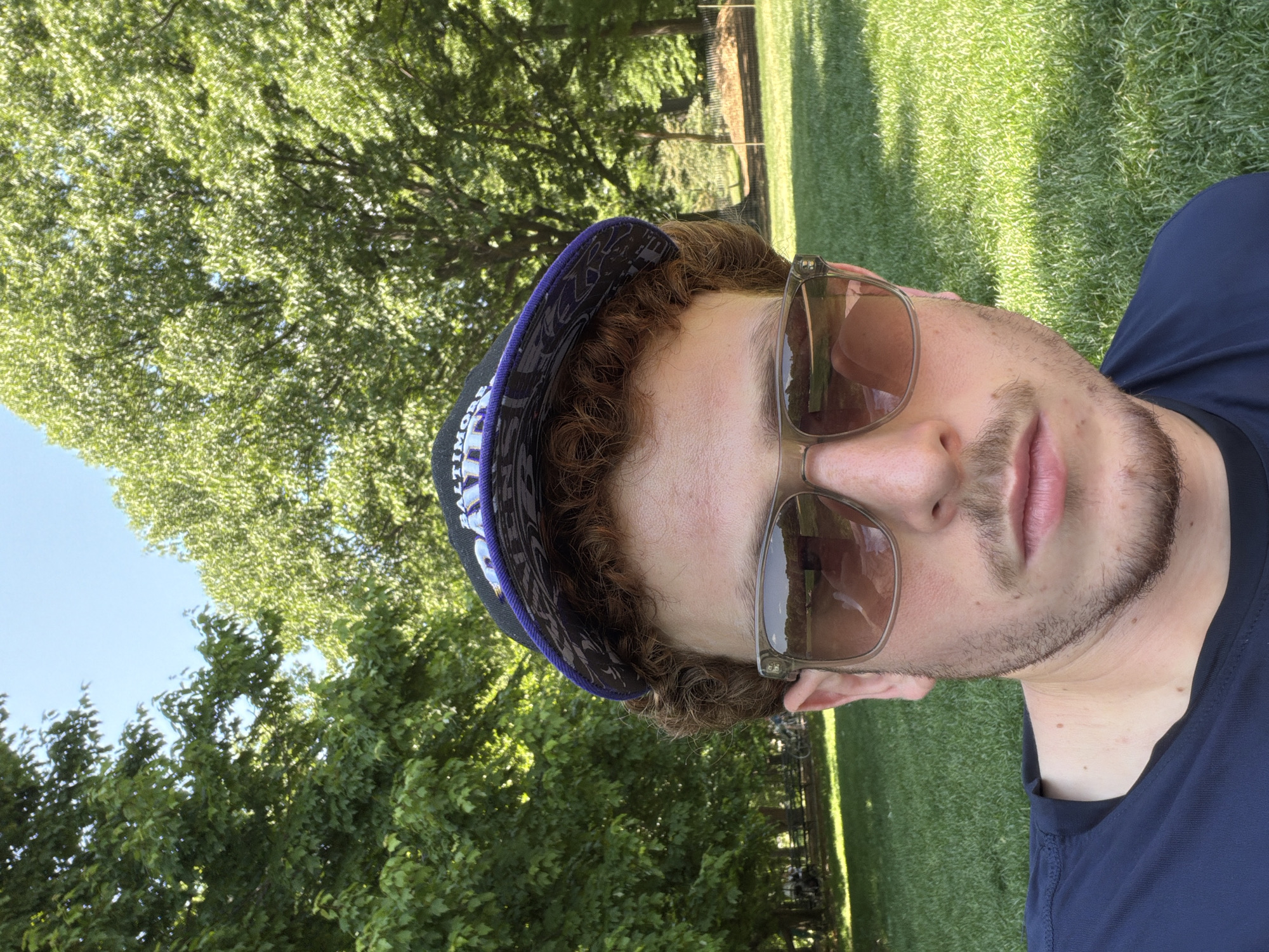 Man rests on lawn wearing Ravens cap in NYC