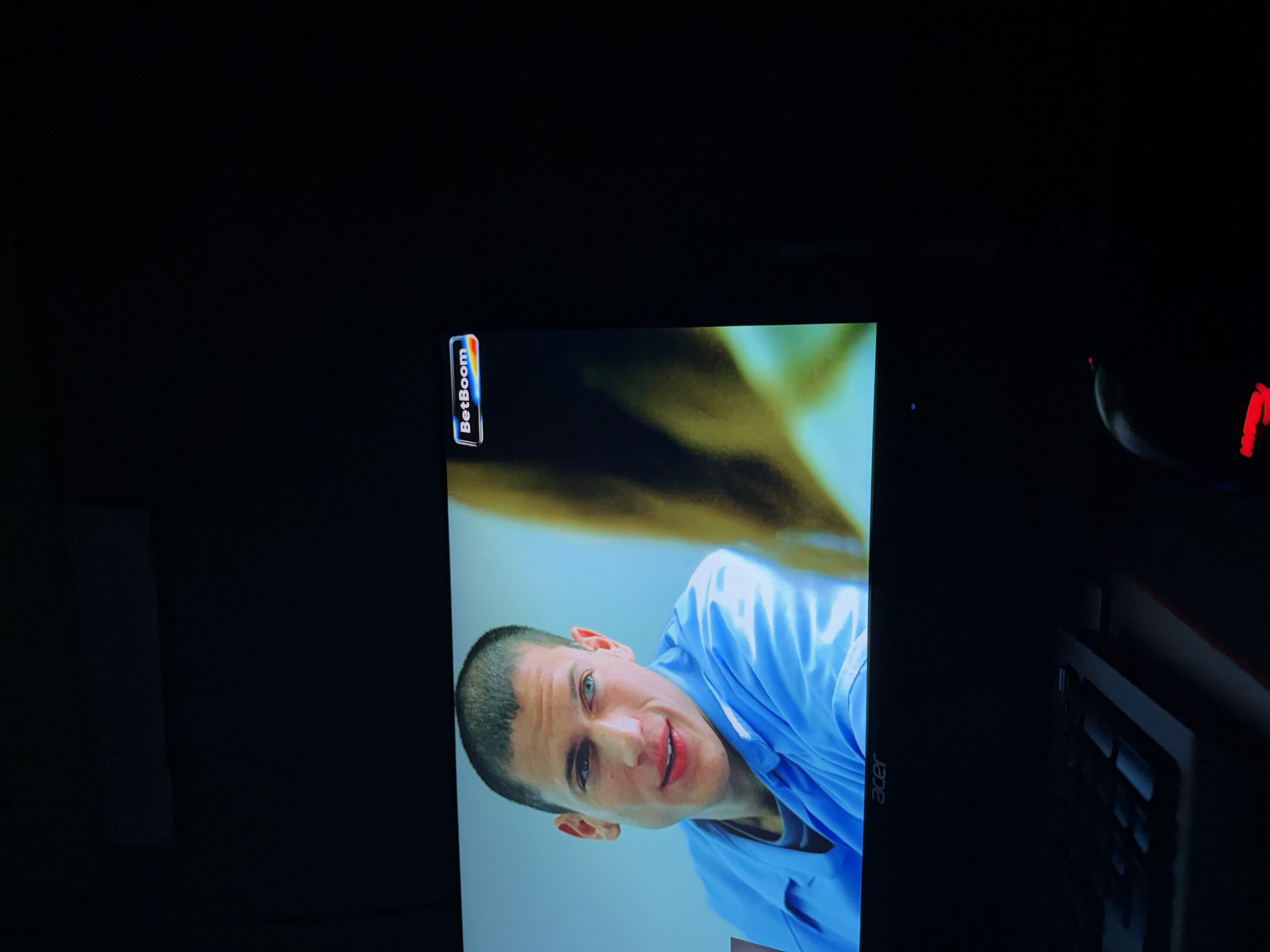 Computer monitor displays man in blue shirt with BetBoom logo
