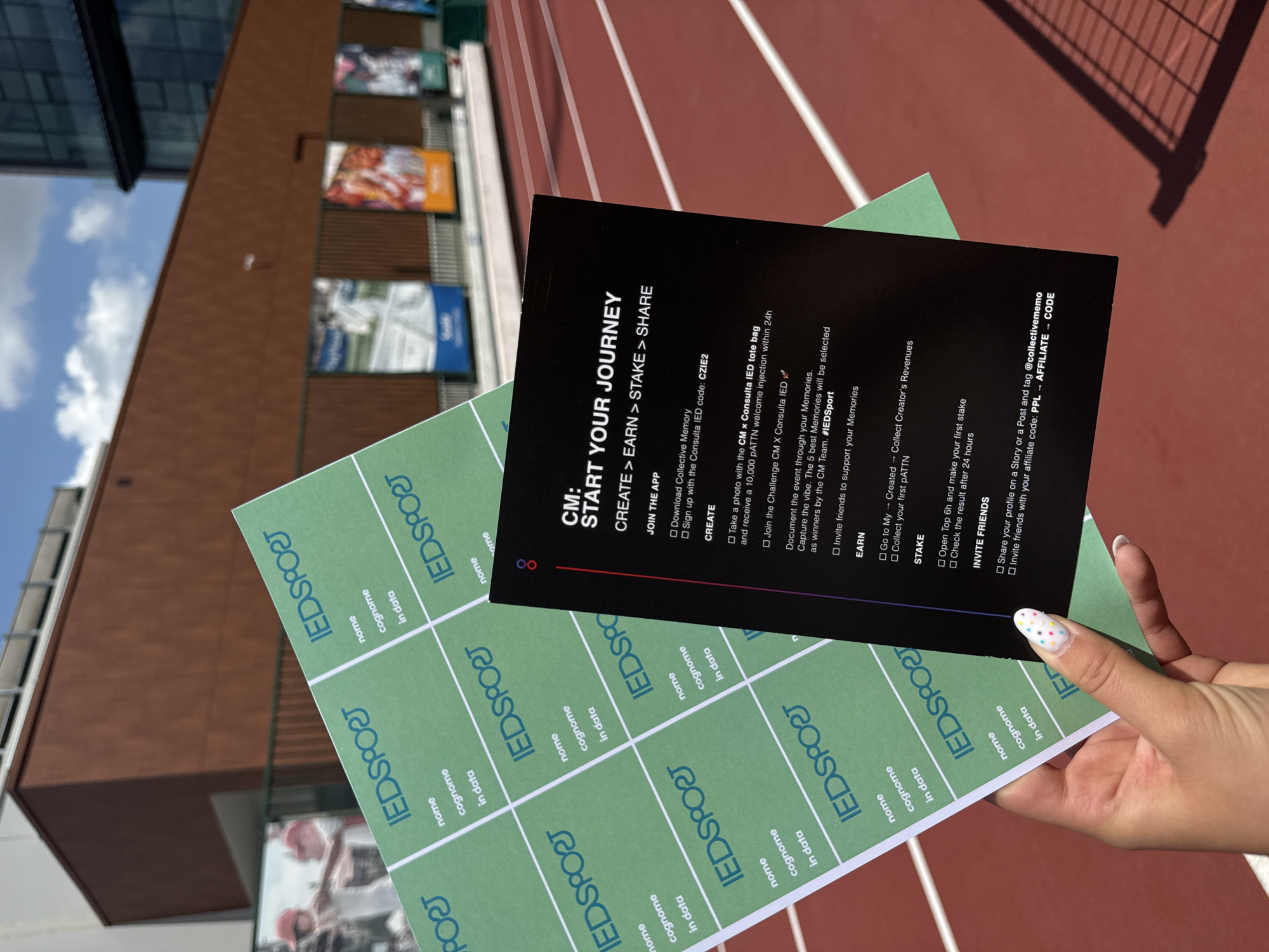 Person holds documents over Milan running track with decorated nails
