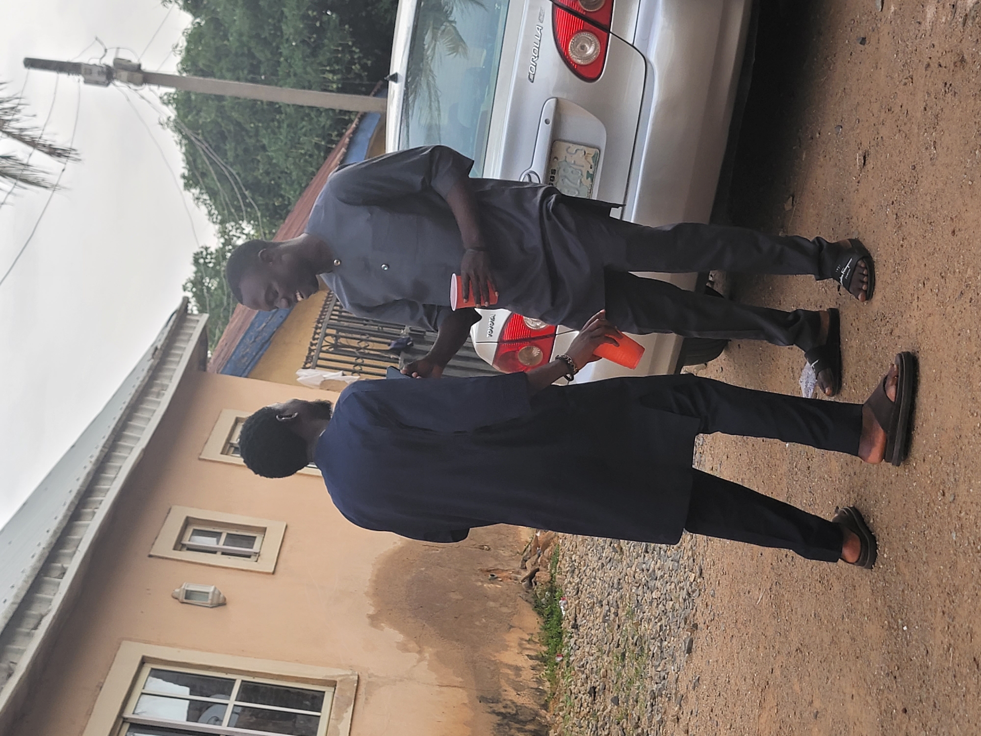 Men gather outside building in Jos, Nigeria