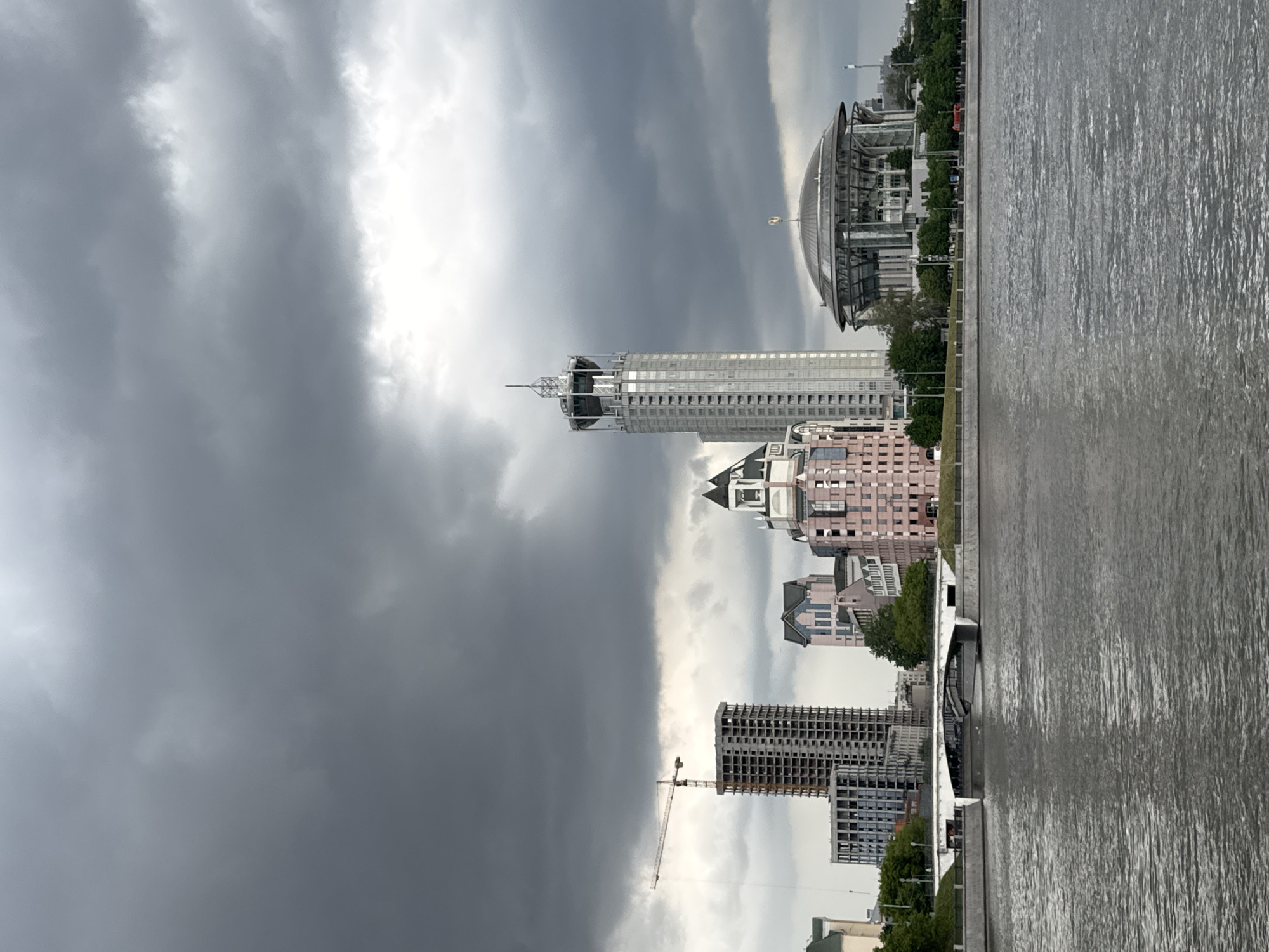 Passenger boats docked along Moscow River under cloudy skies