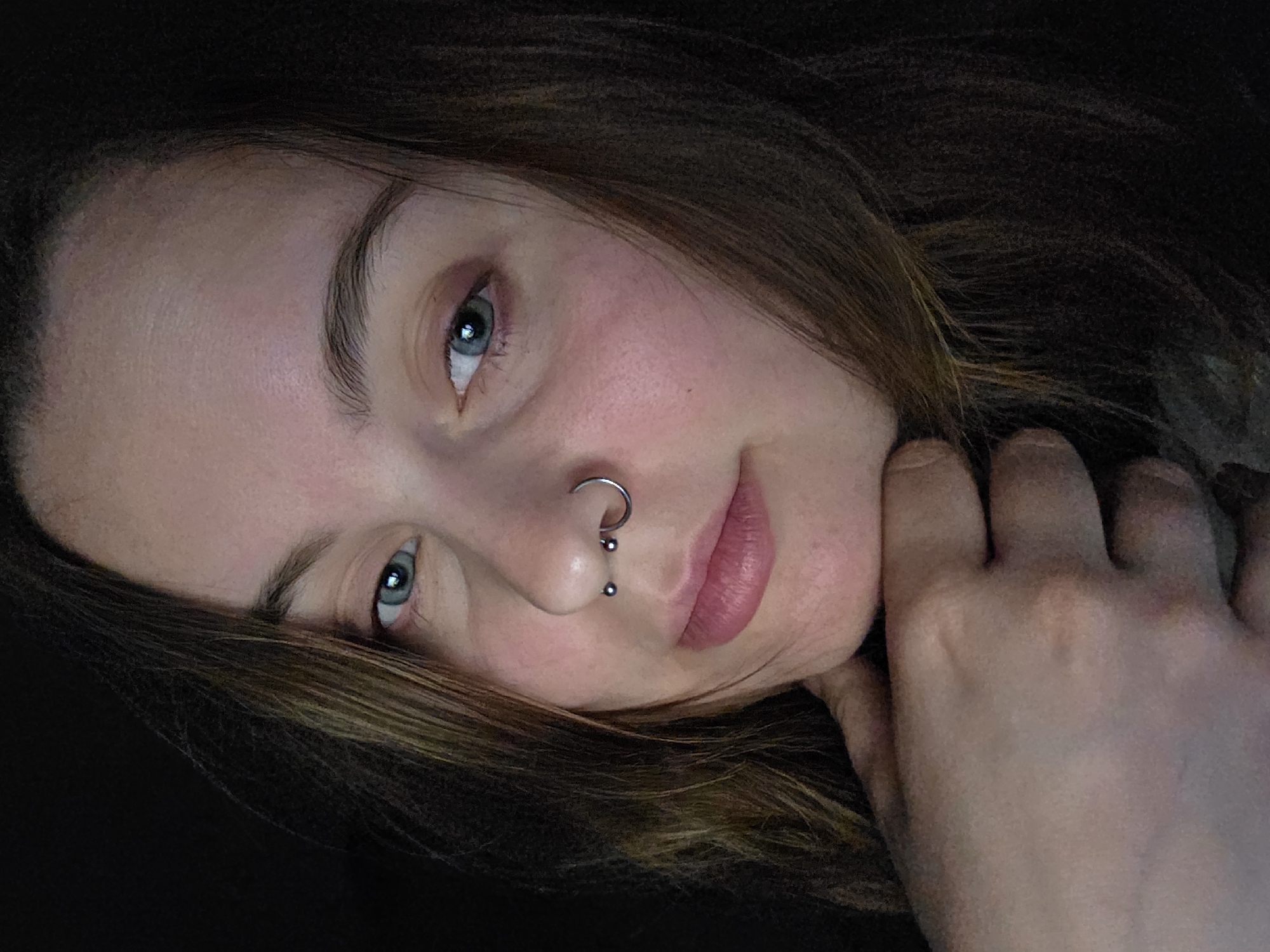 Portrait session captures woman with piercings, laptop keyboard documented