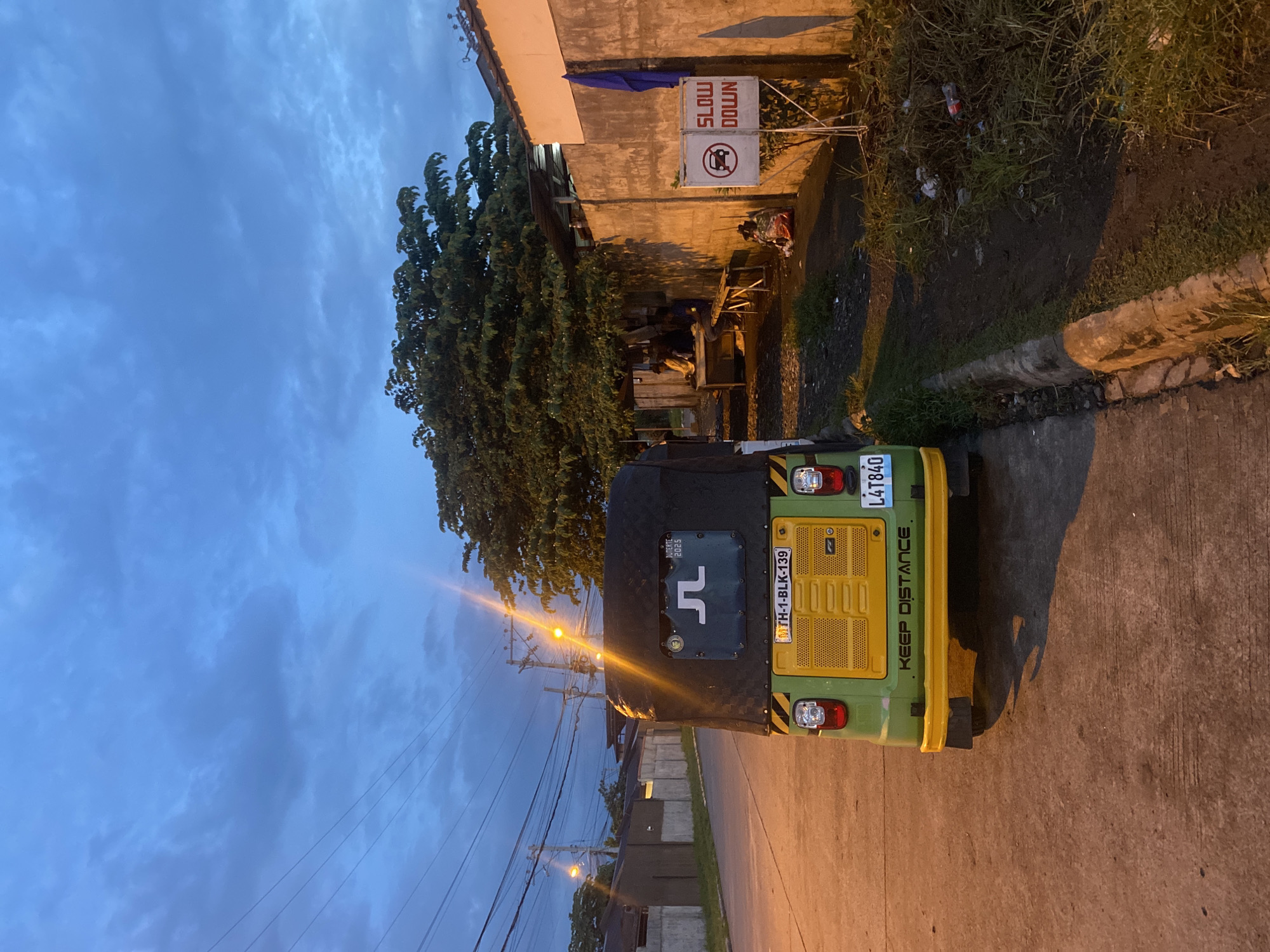 Davao City street at dusk, vehicles parked along a residential road