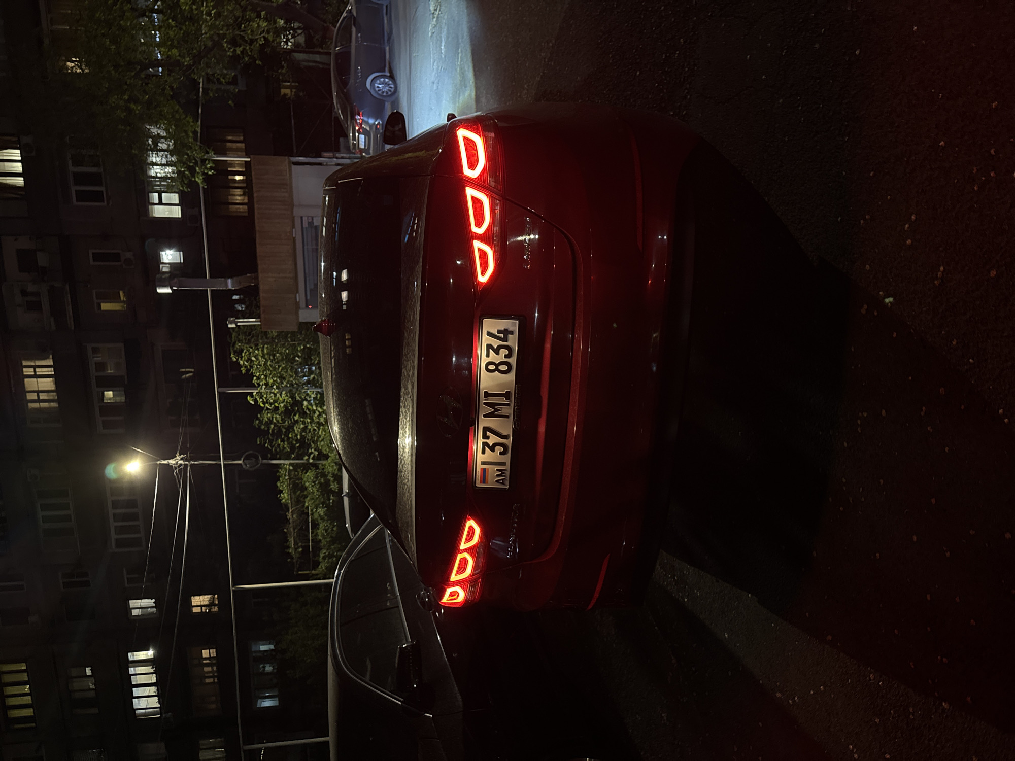 Maroon car with illuminated taillights parked on Yerevan street
