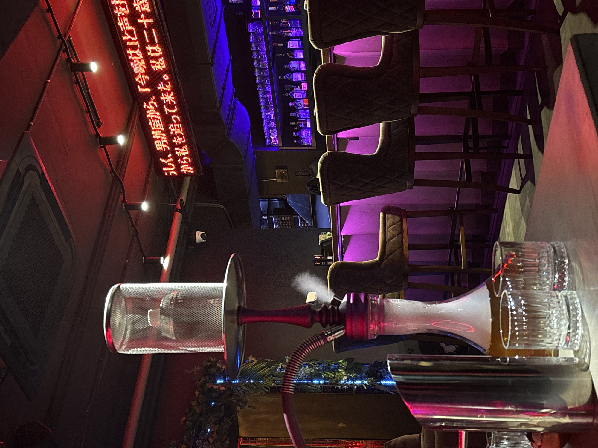 Neon-lit hookah lounge in Kazan with robotic decor and Japanese signage