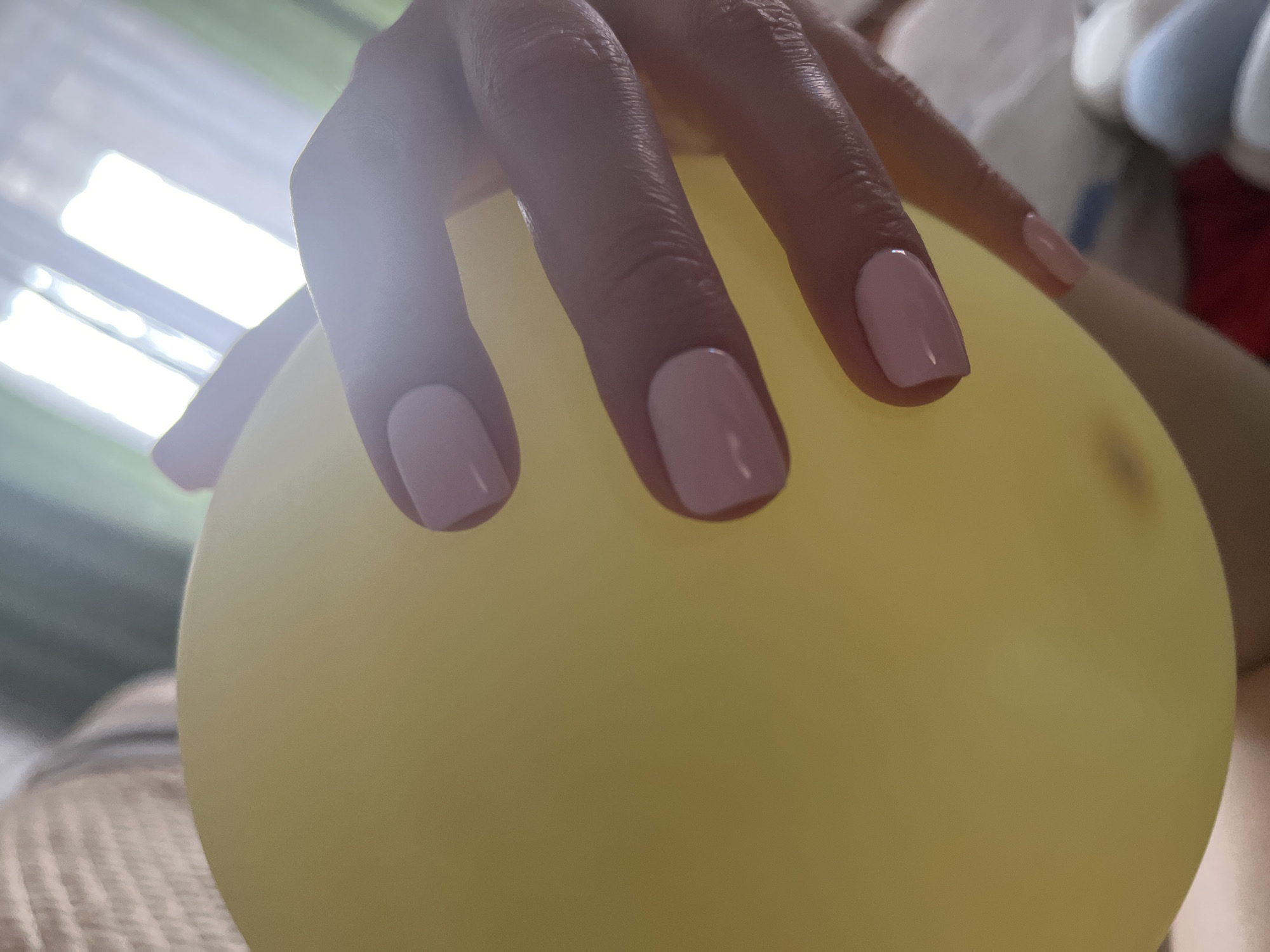 Yellow balloon held close, soft indoor light, Vladikavkaz