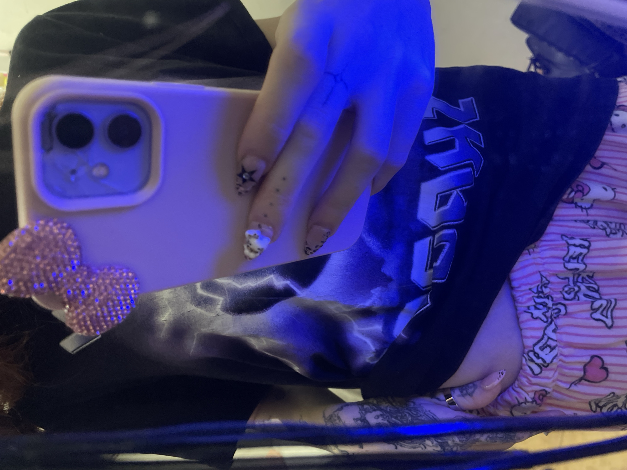 Person documents personal moments with decorated phone, Hello Kitty balloons