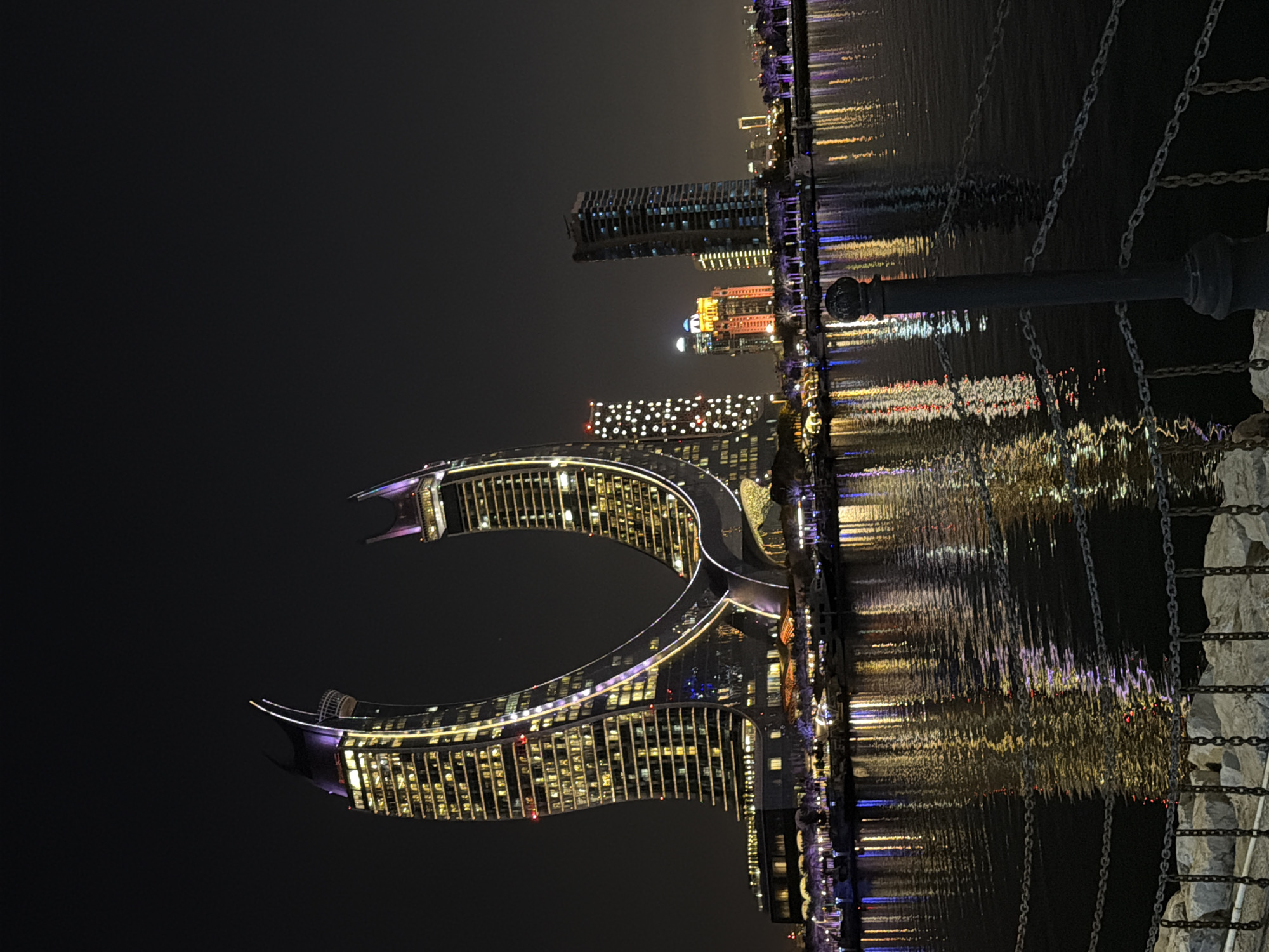Katara Towers illuminate night sky with purple, yellow lights