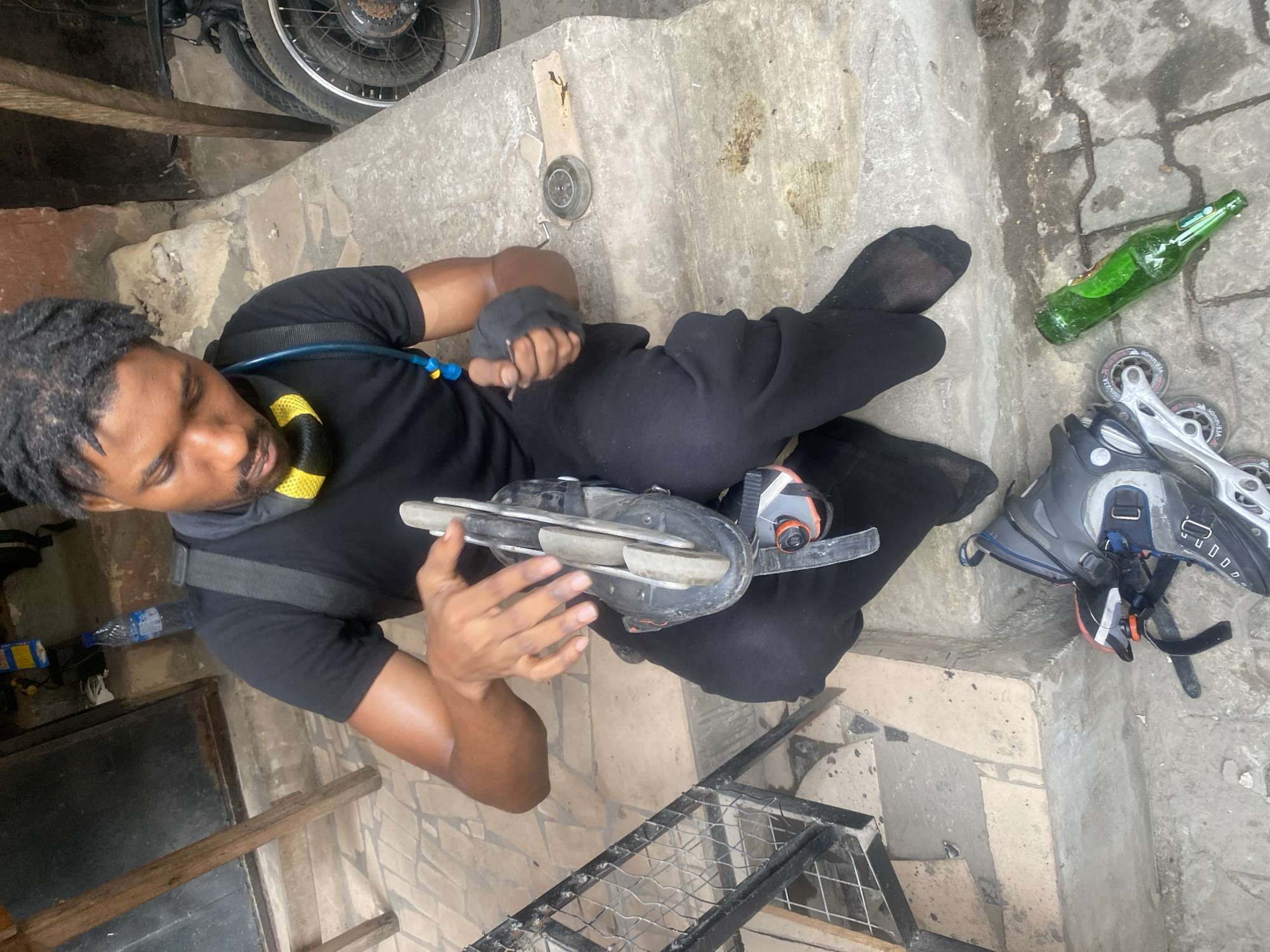Man handles inline skating gear on Lagos concrete steps