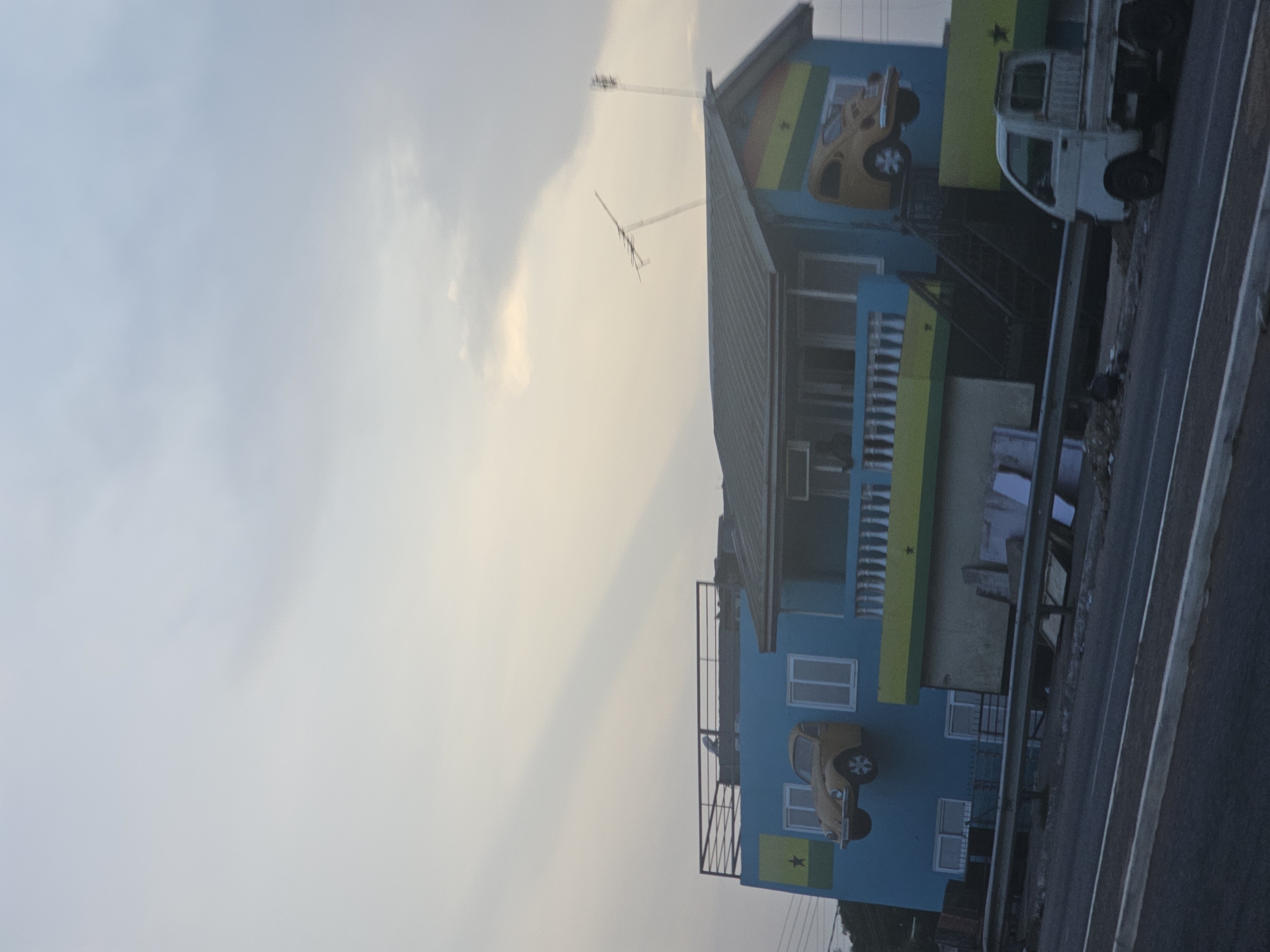 Colorfully painted building with car murals observed in Accra