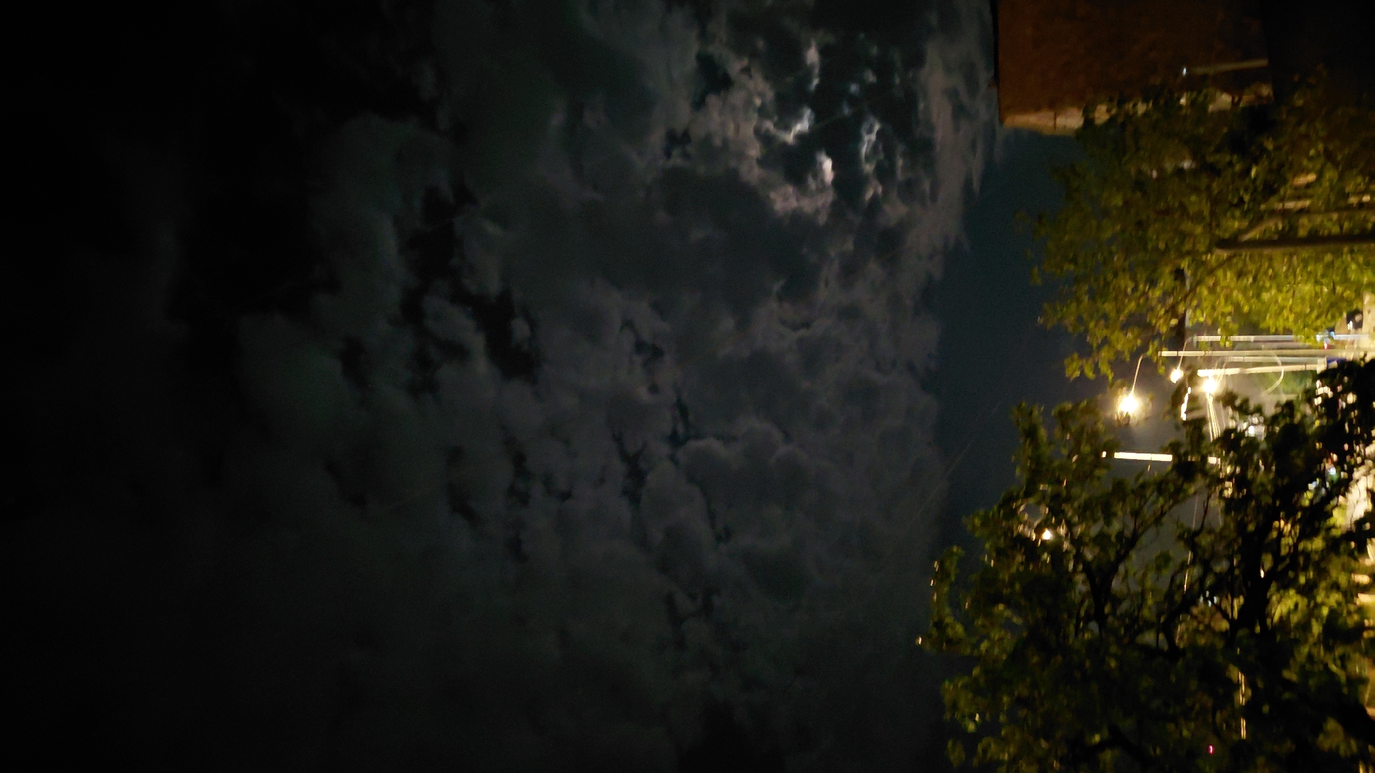 Moonlit night sky over Abovyan, clouds and streetlights below