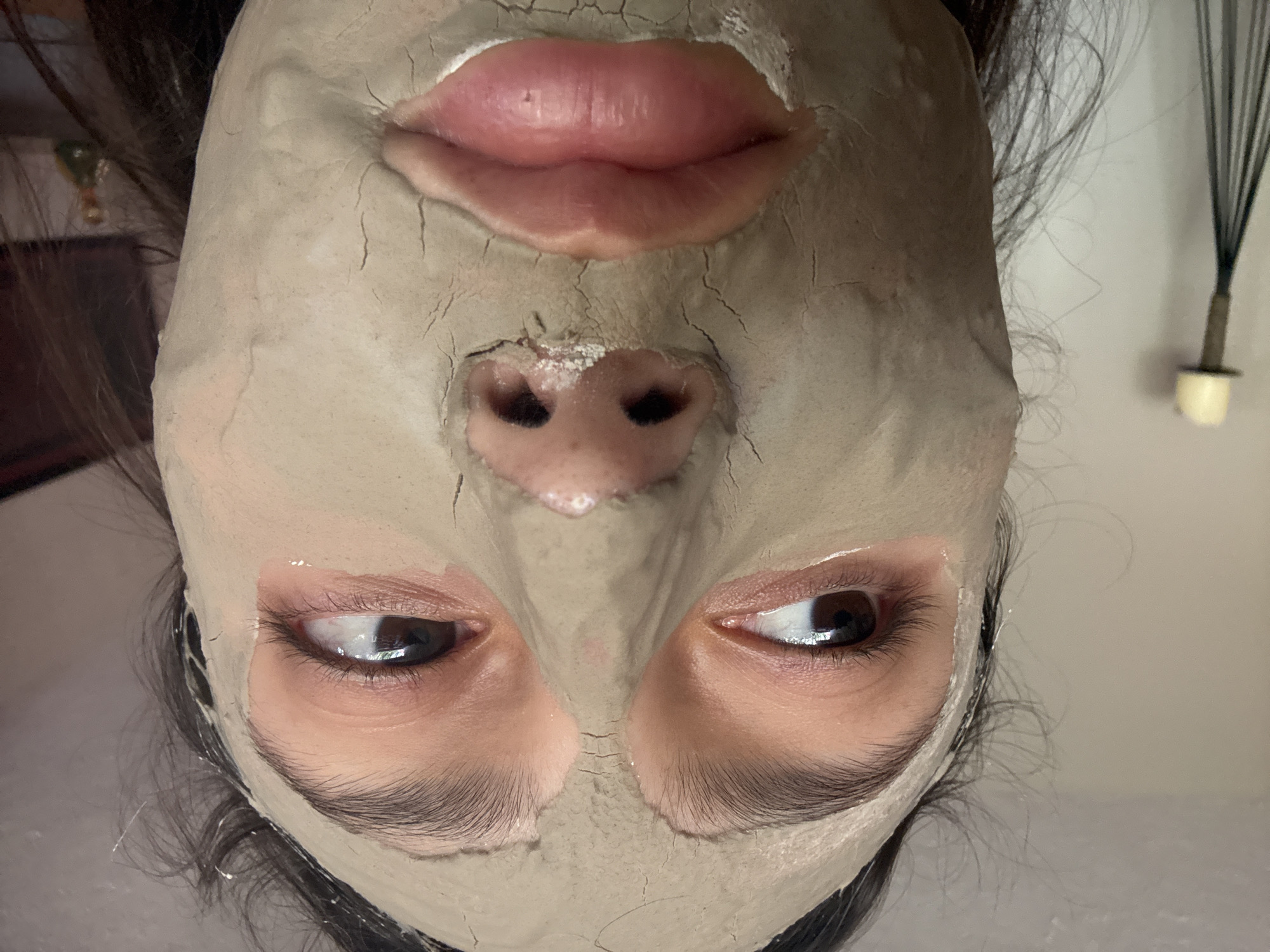 Person photographed wearing cracked clay facial mask in Mexico City