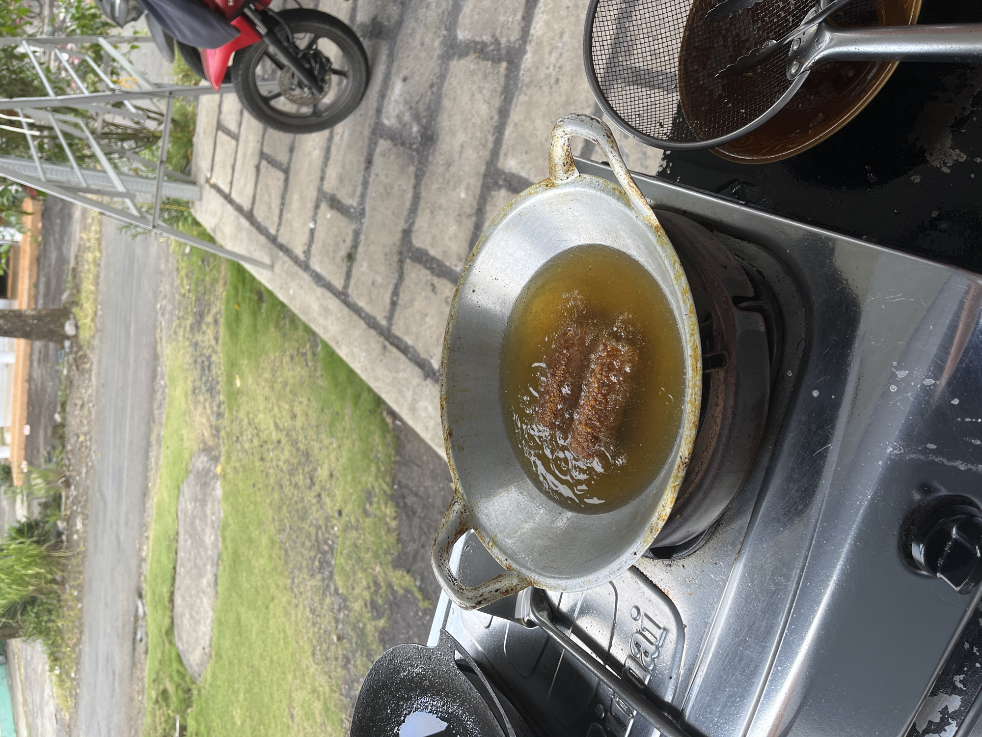 Street-side frying and parked bikes in Jambearum, Indonesia