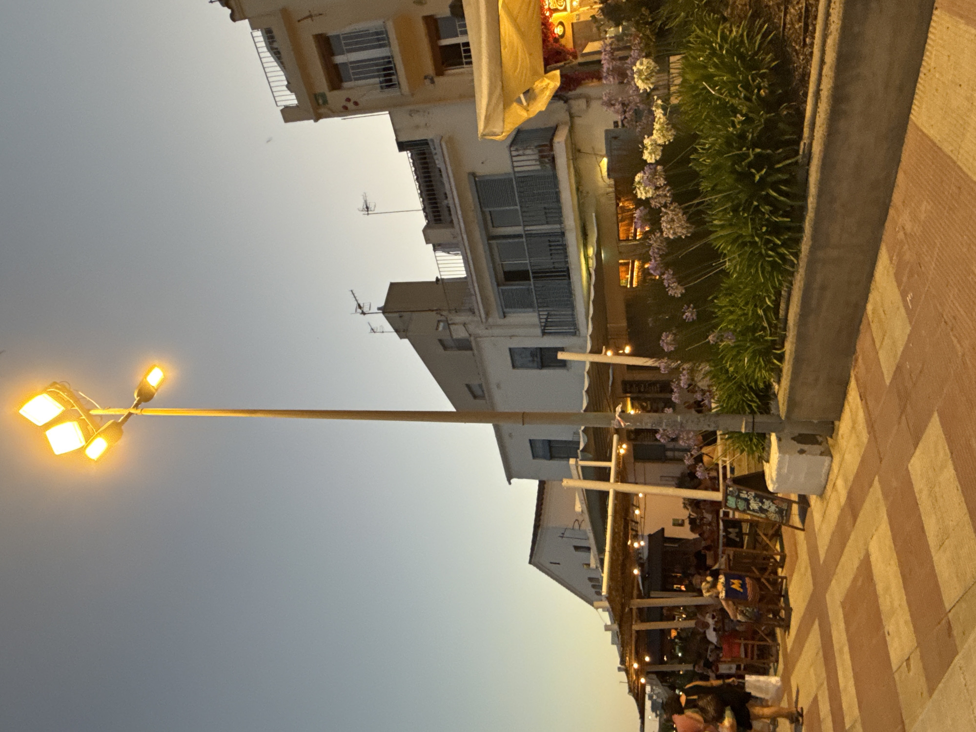 Blanes beach and promenade at dusk, boats and evening crowds