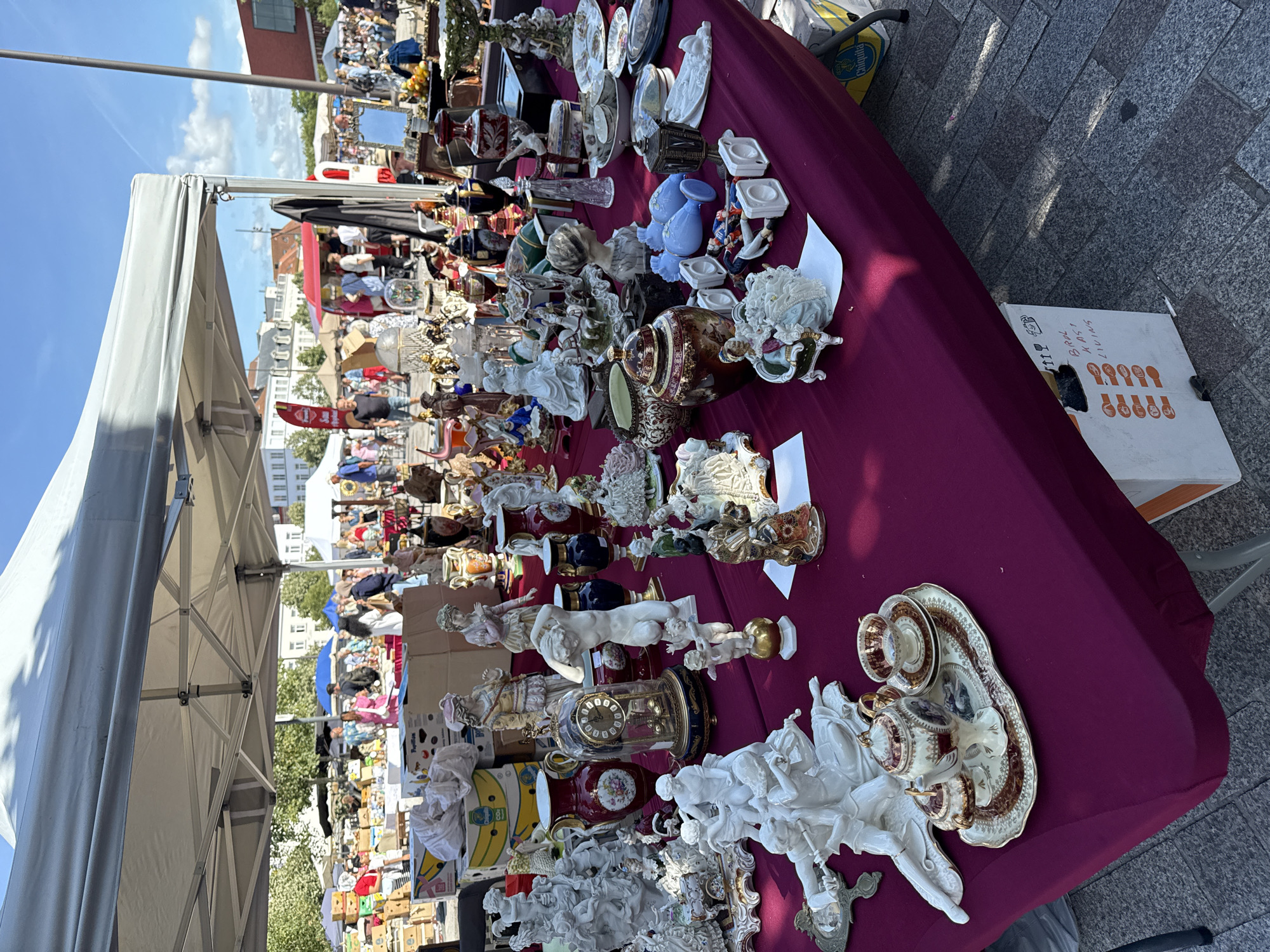 Antique flea market browsing on Bruges cobblestones