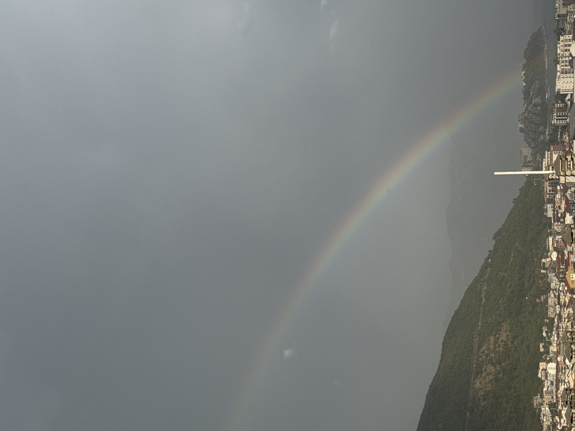 Rainbow over Budva's coastal skyline on a cloudy afternoon