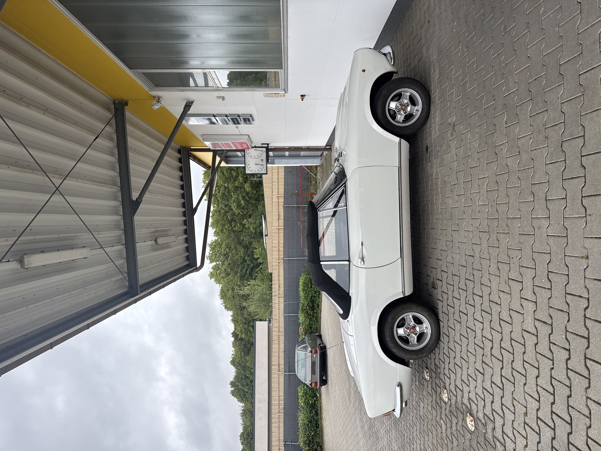 White Fiat 124 Spider parked under awning in Wettstetten