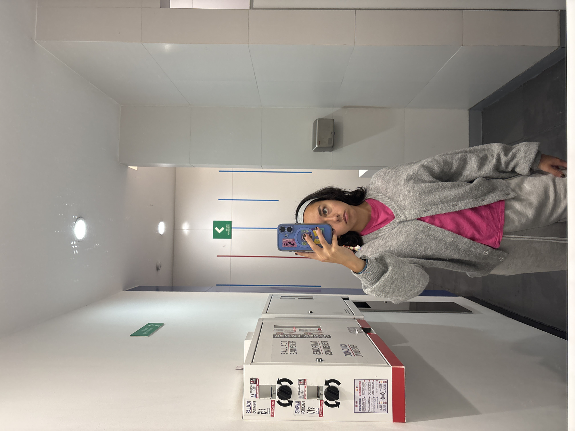 Young woman takes mirror selfies in Mexico City public facility