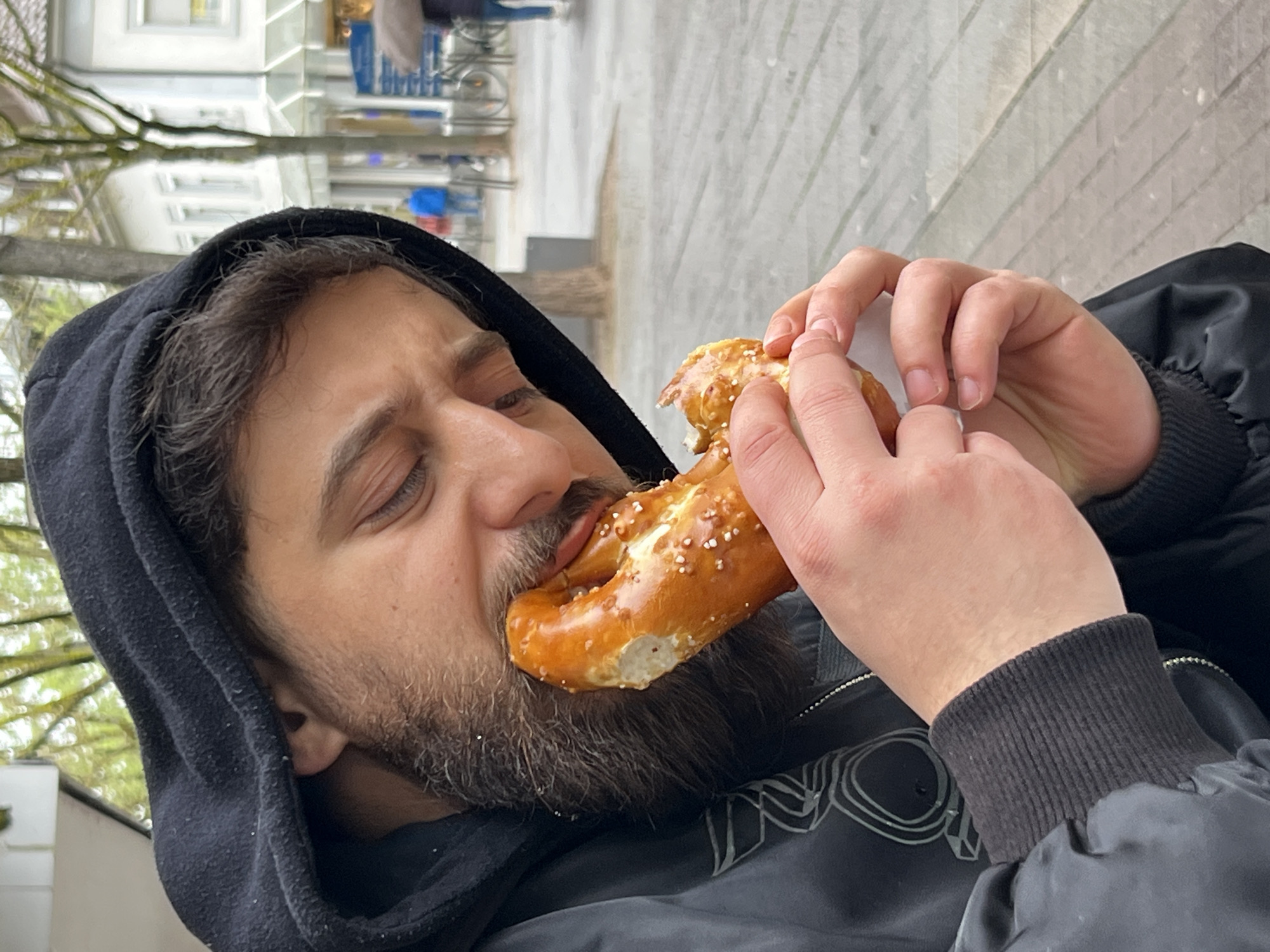 Man enjoys pretzel and coffee in downtown Kehl, Germany