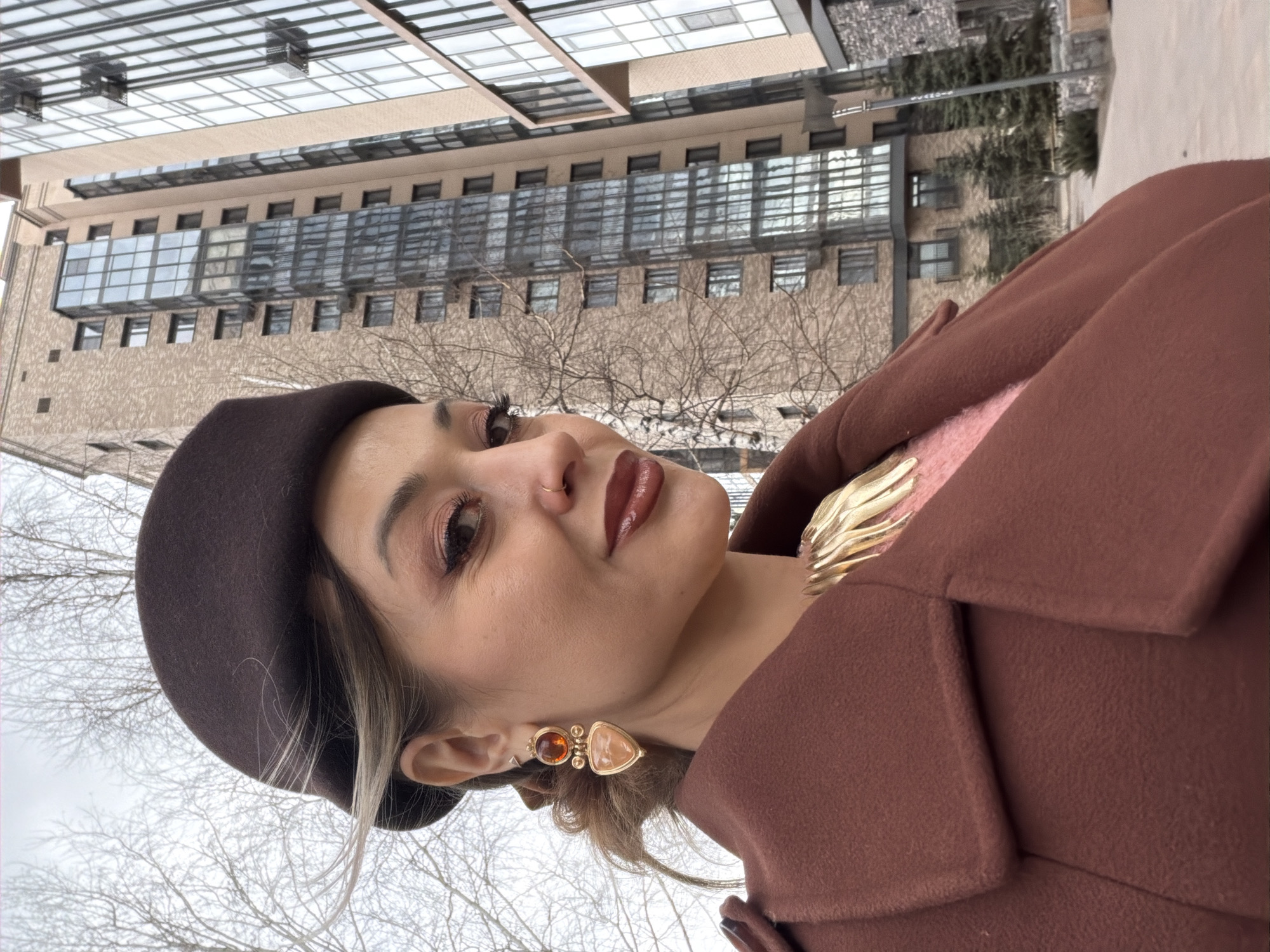 Woman in brown beret photographed outside buildings in Krasnoyarsk