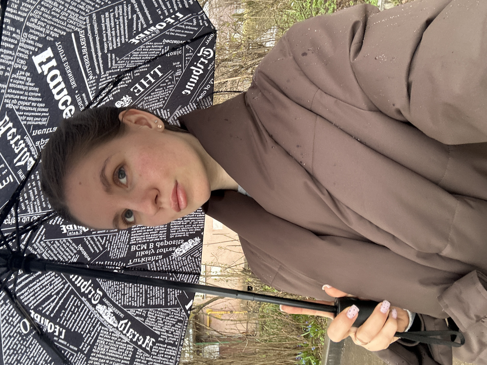 Woman with umbrella, baby in car seat observed in Klin