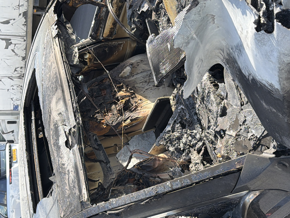 Fire-damaged car and sleeping cat observed in Holon