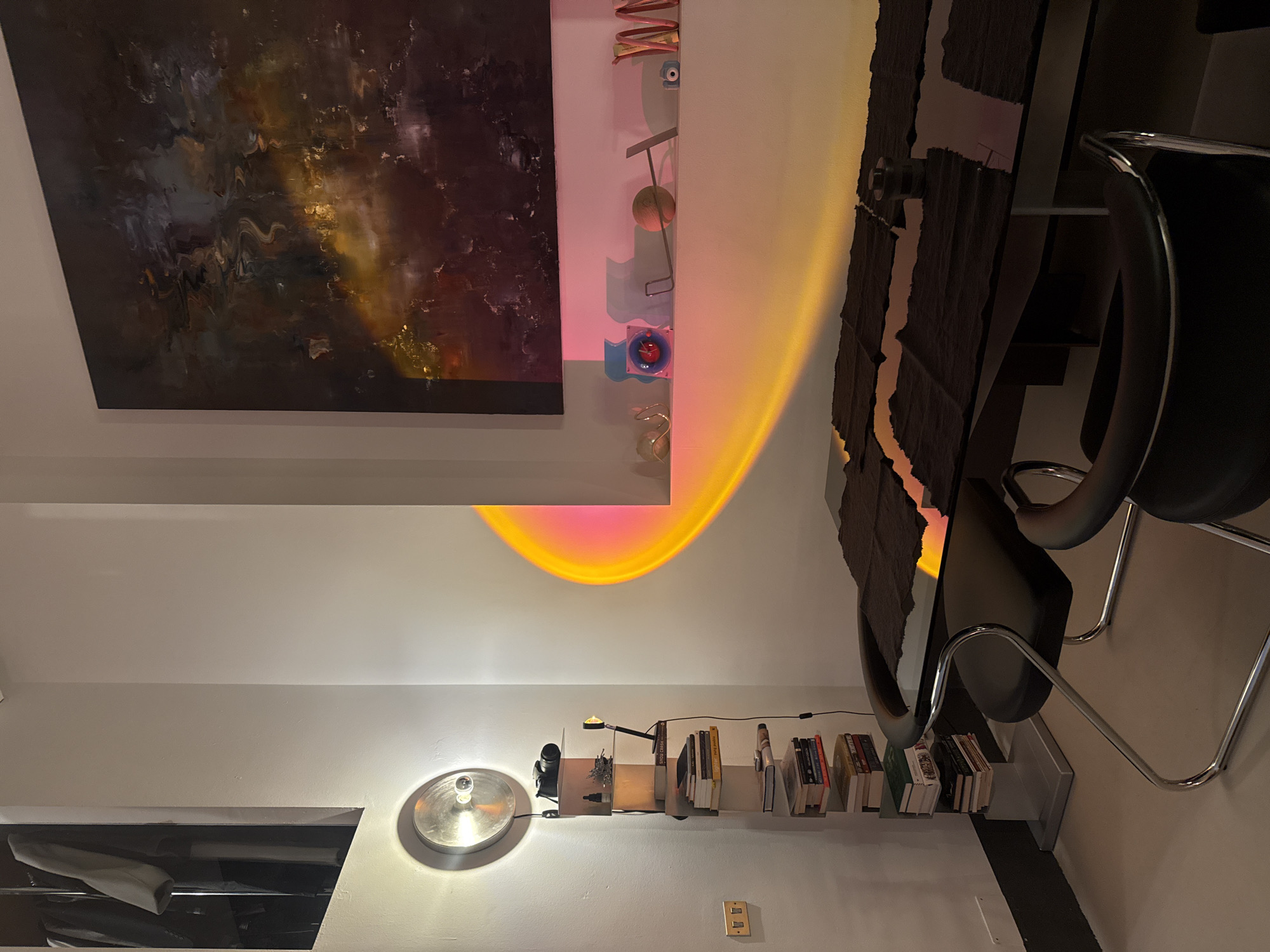 Milan interior space documented with art, books, pink mirror