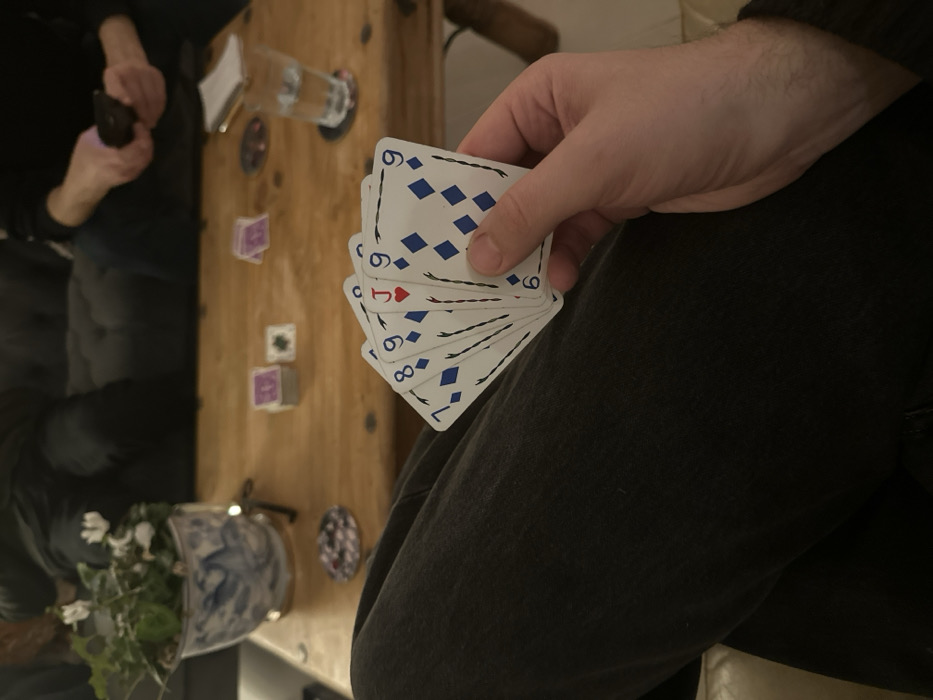 Card player holds hand with jack, diamonds in West Suffolk