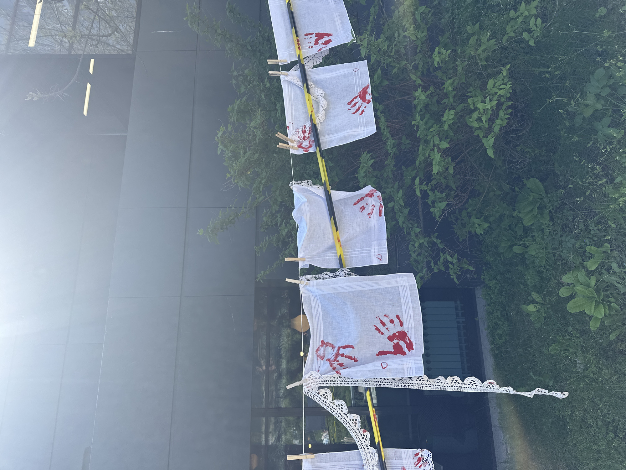 Handprint-decorated handkerchiefs displayed on pole in Sofia