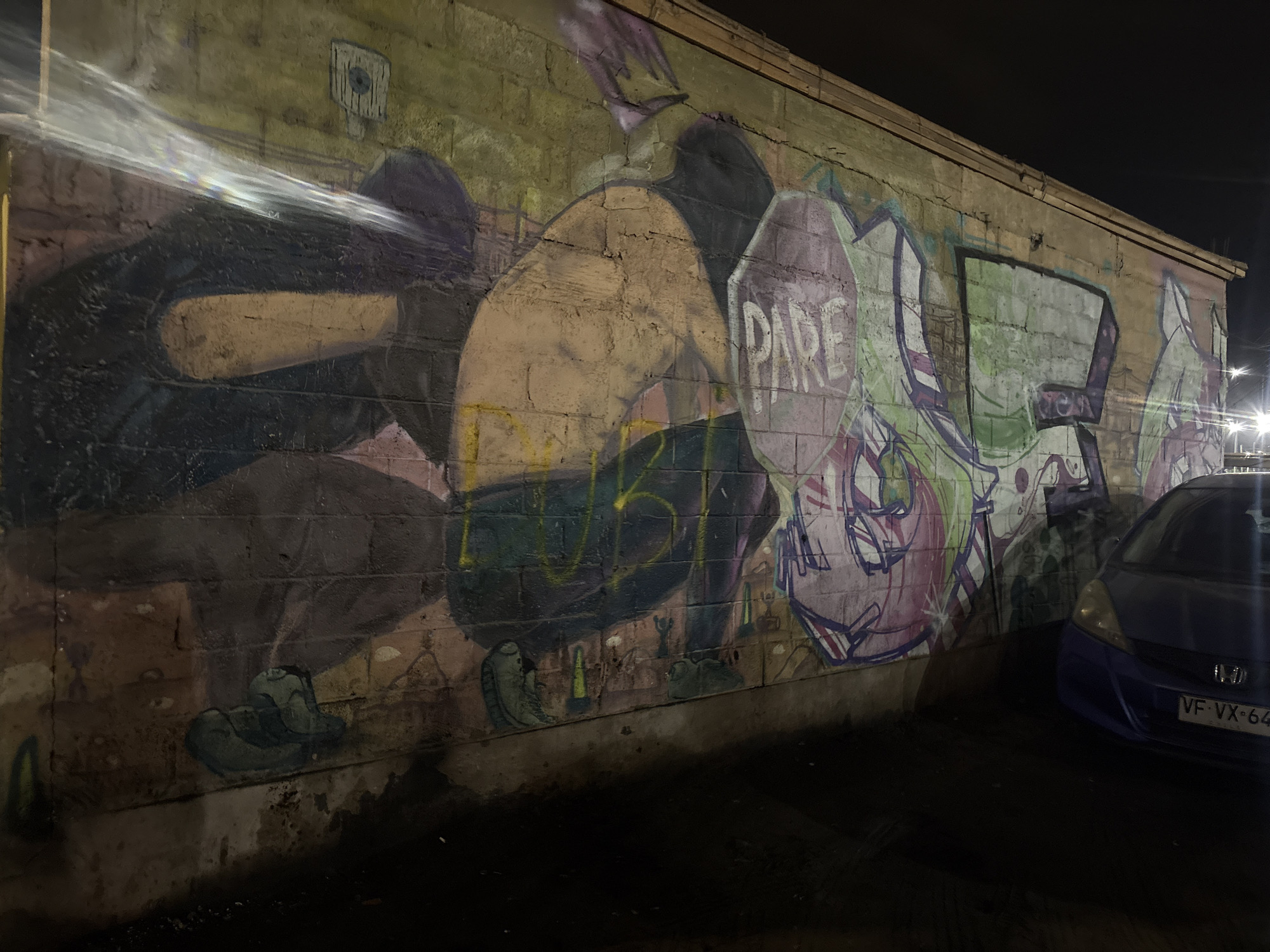 Late night urban scenes documented: graffiti, pizza, parked cars