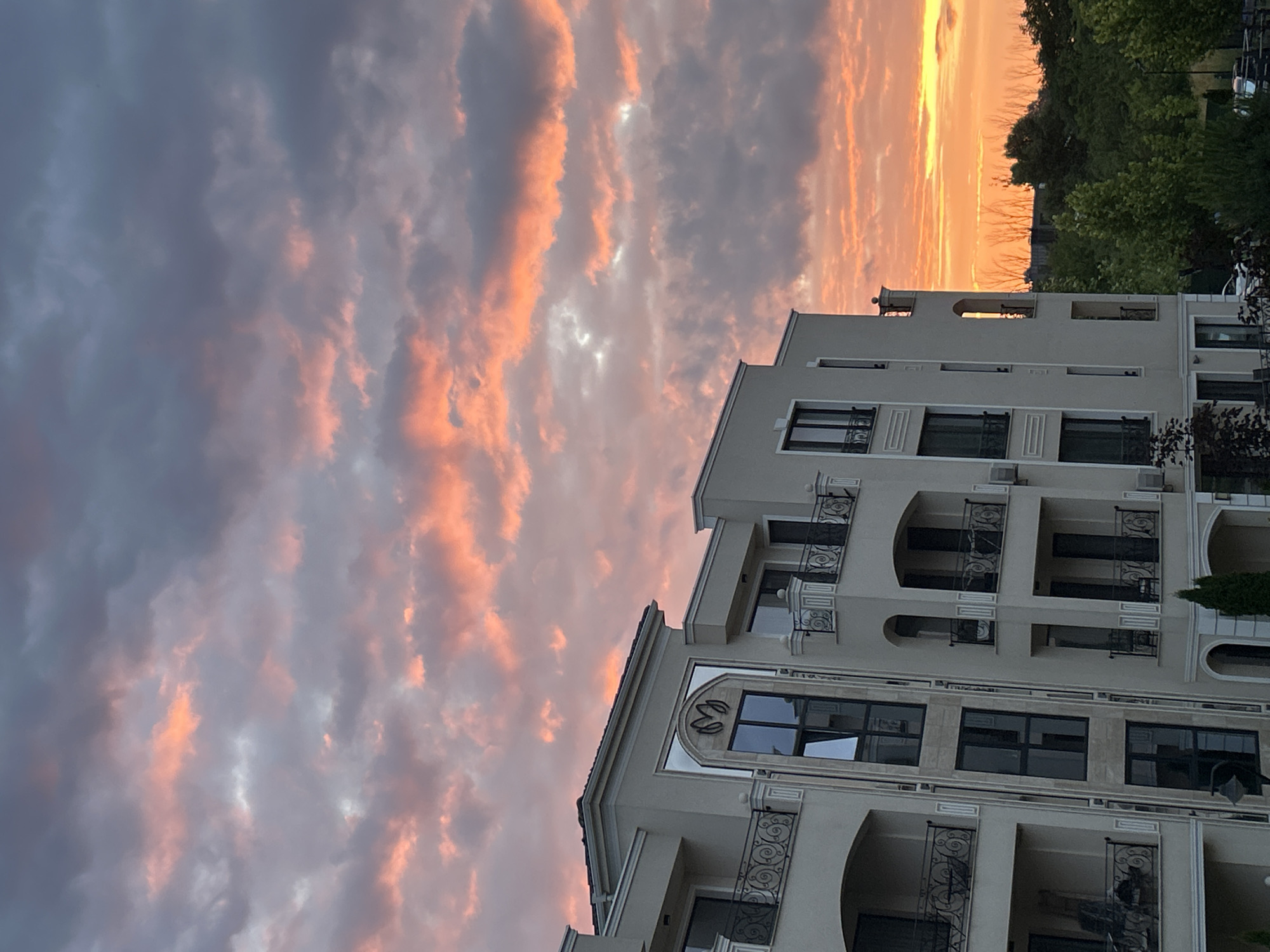 Dramatic sunset documented over Plovdiv apartment buildings with balcony flowers