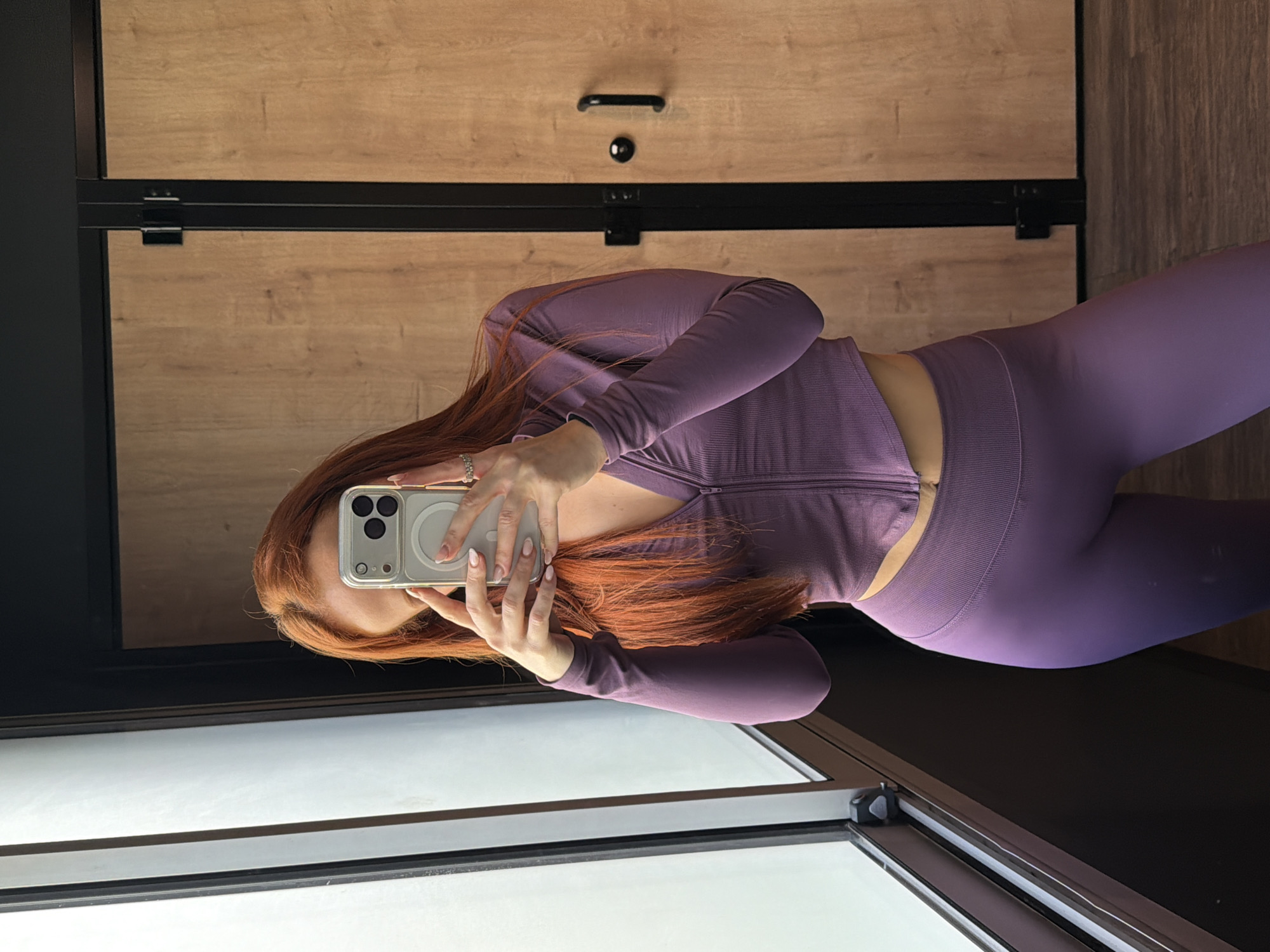 Woman takes selfie in purple athletic wear in Paris dressing room