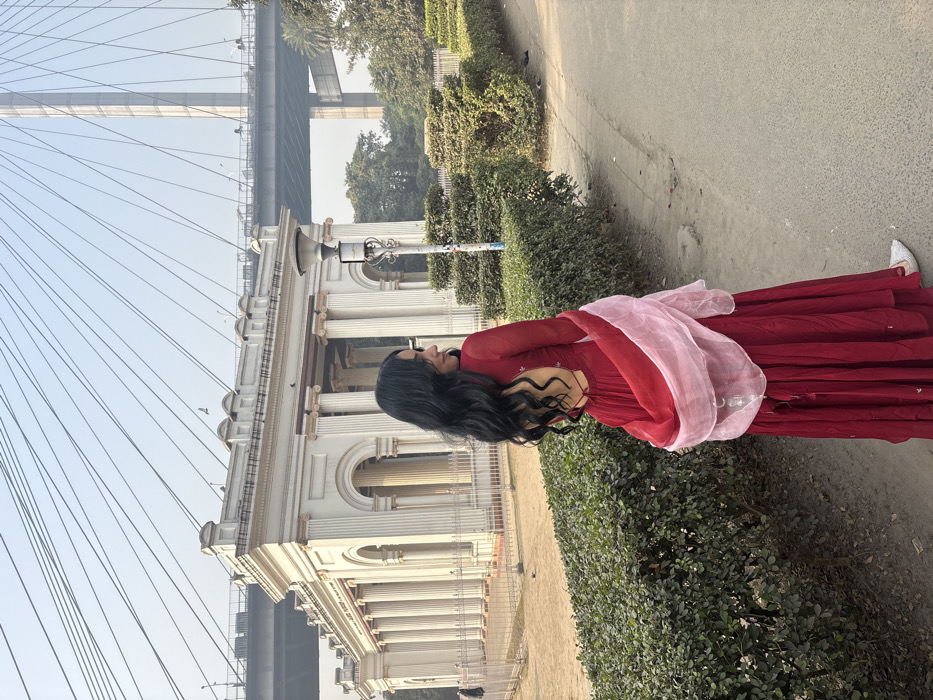 Woman photographed near historic building and bridge in Kolkata