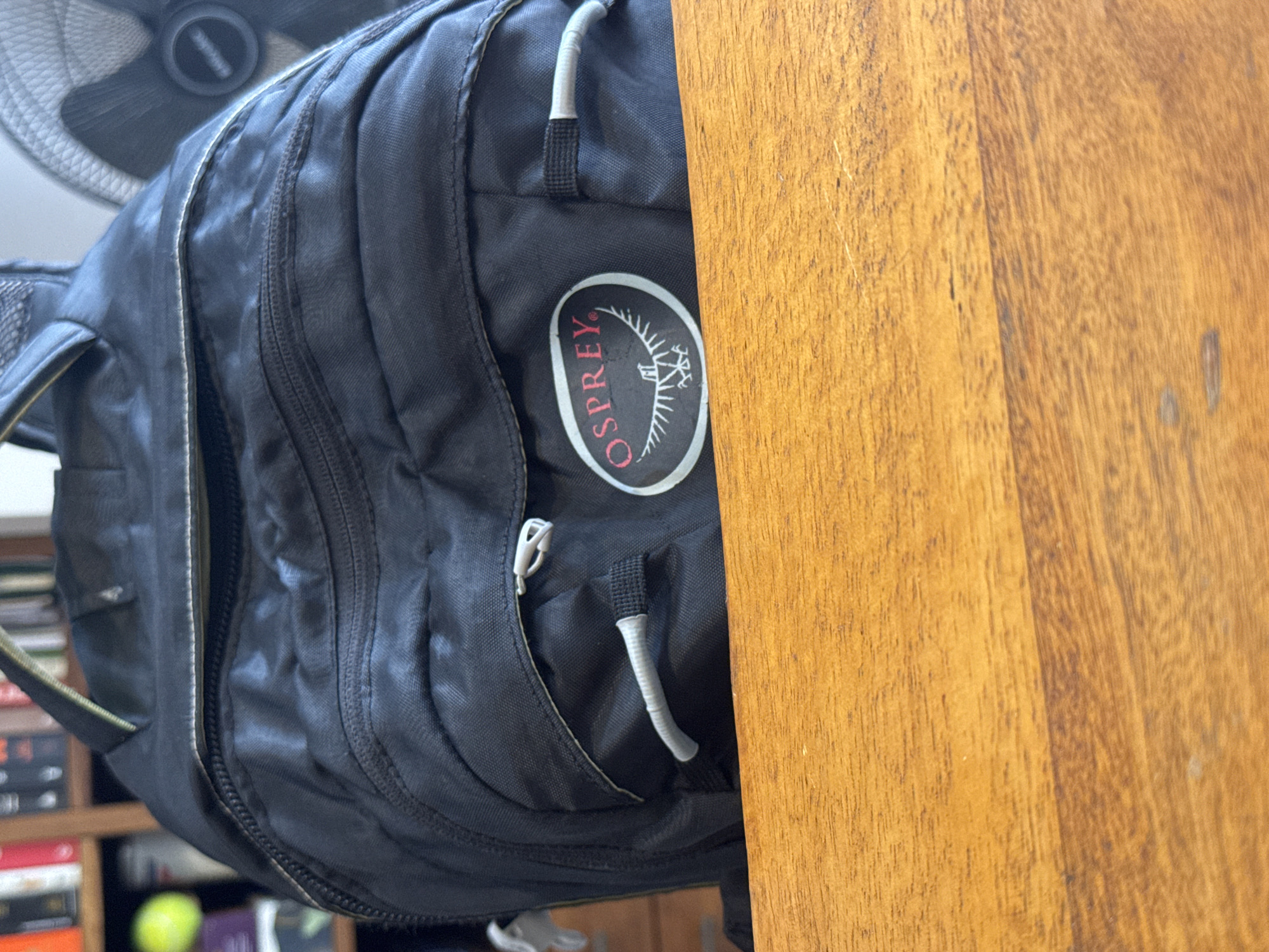 Black backpack observed against wooden surface in Denpasar